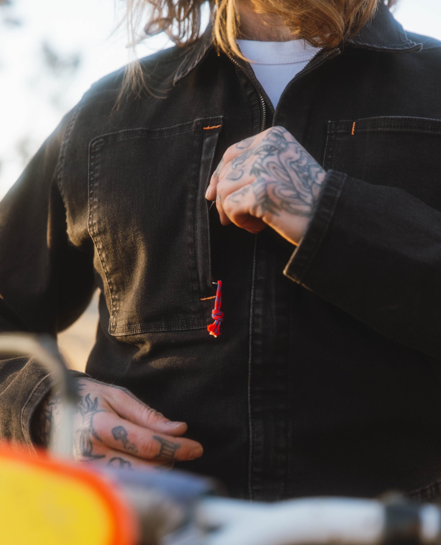 Tattooed hand and a denim coverall