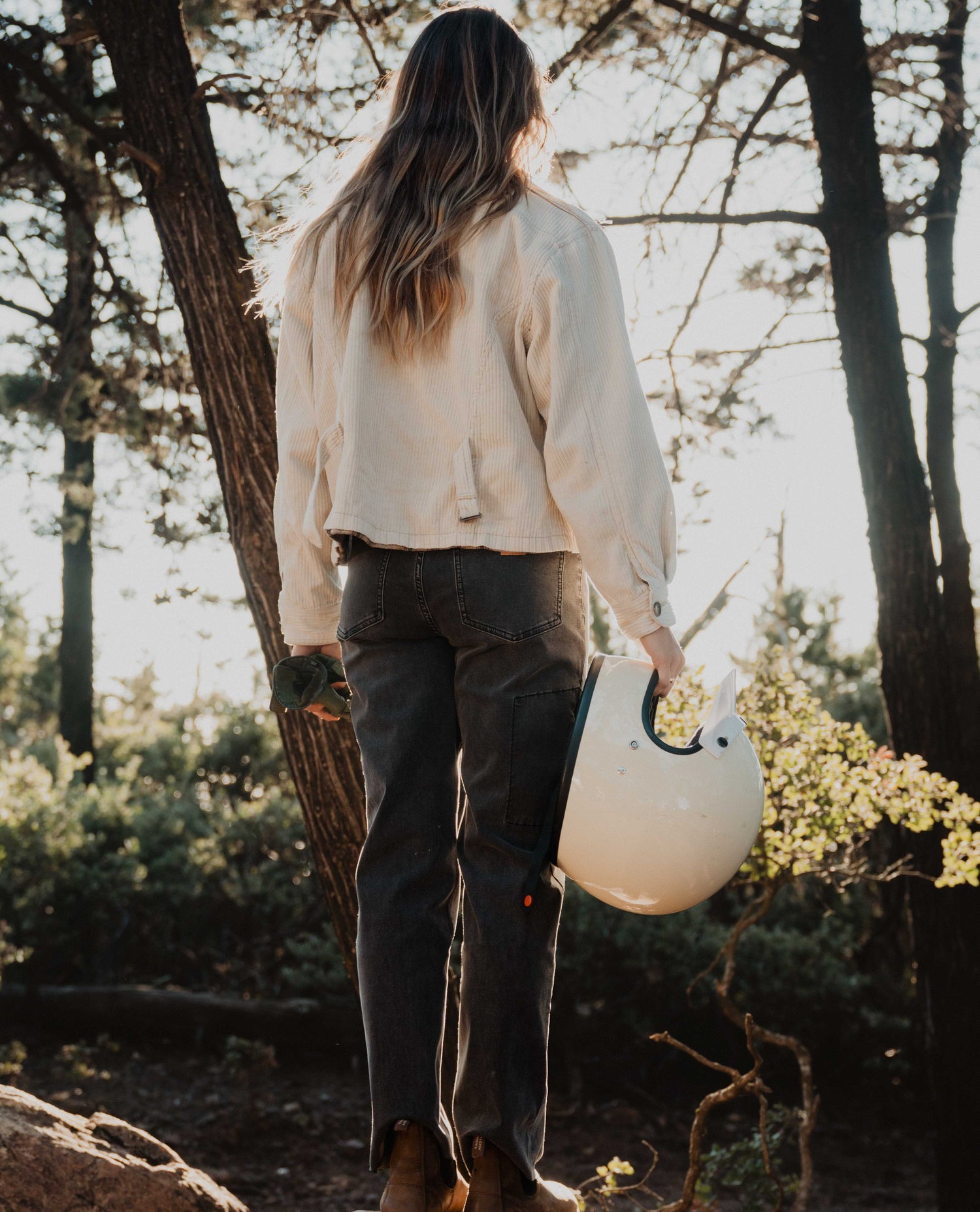 woman facing away with moto helmet in hand