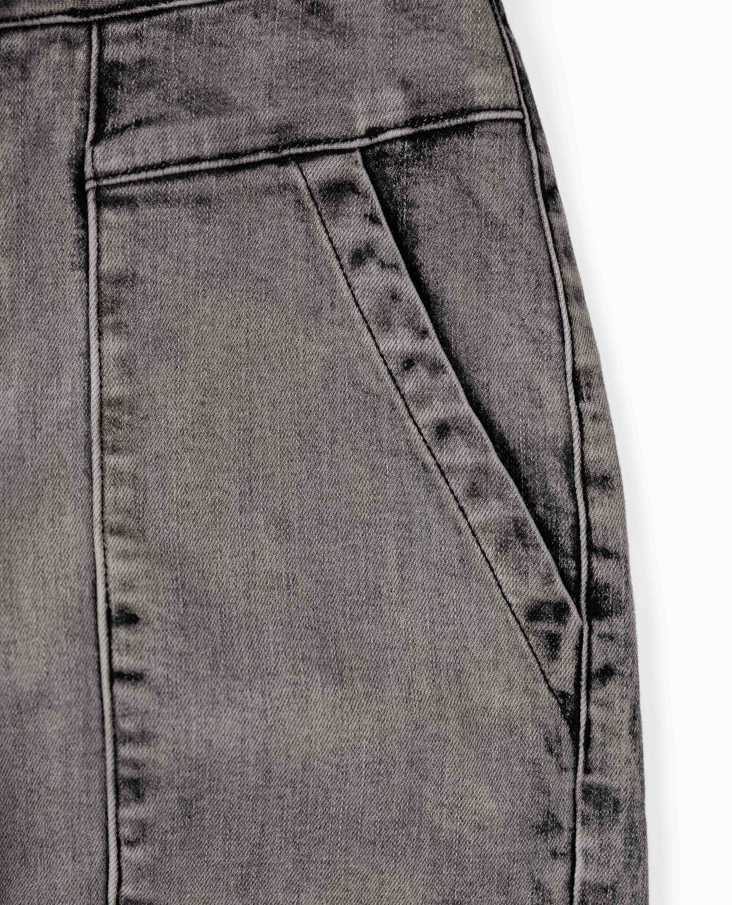 Close-up of gray denim fabric with stitching details on a white background