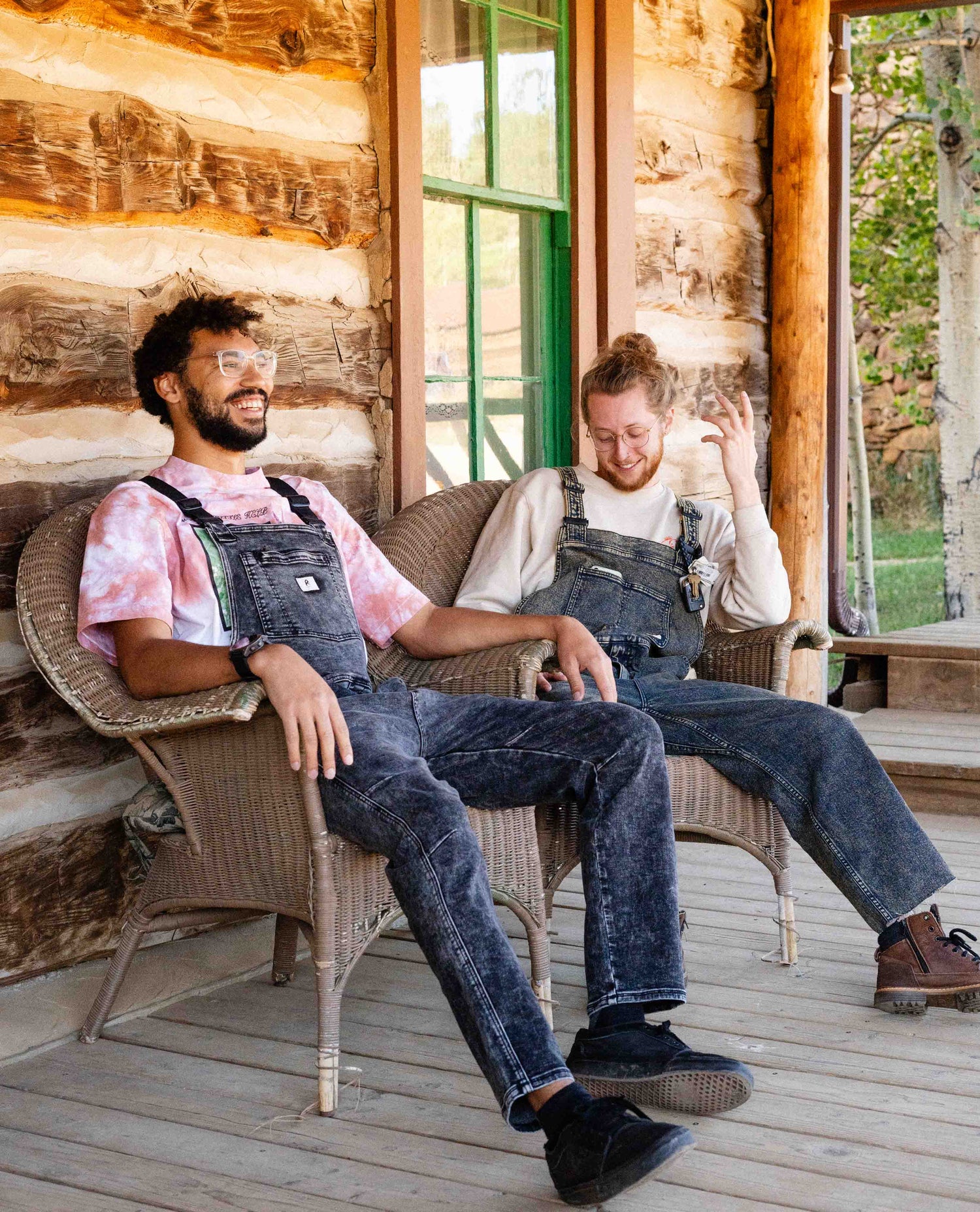 Two guys sitting on a porch in overalls