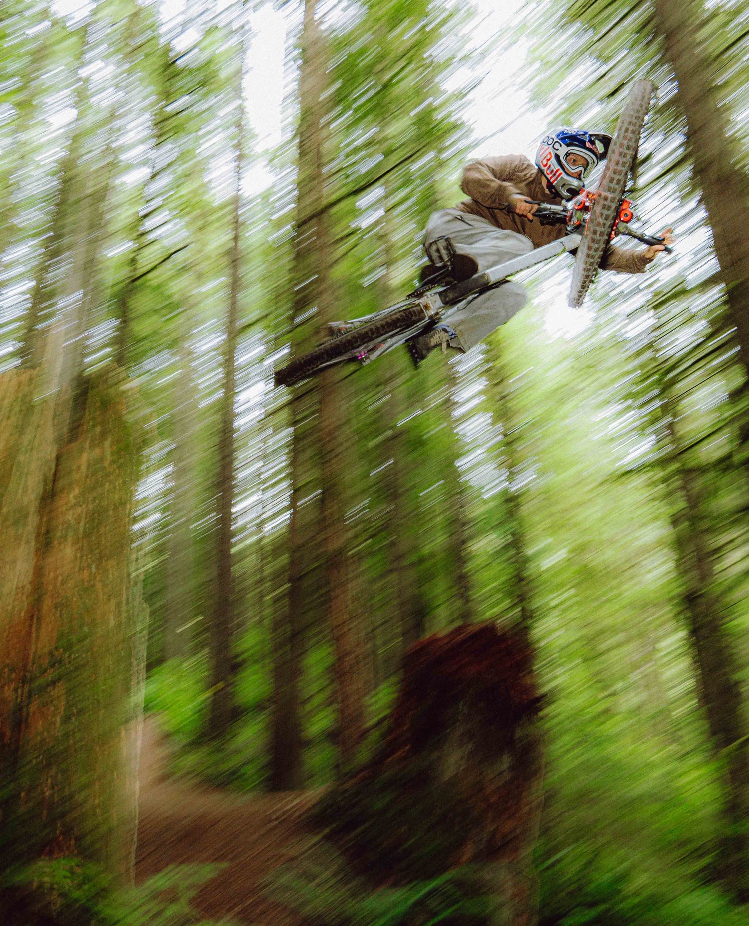 Person on a mountain bike performing a jump in a forest