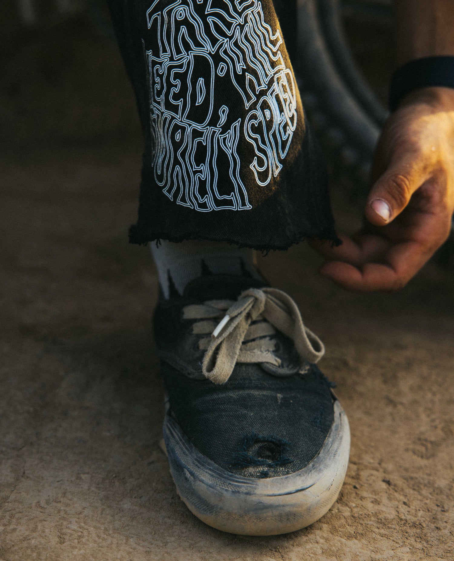 Dirty shoe with worn laces on a textured surface