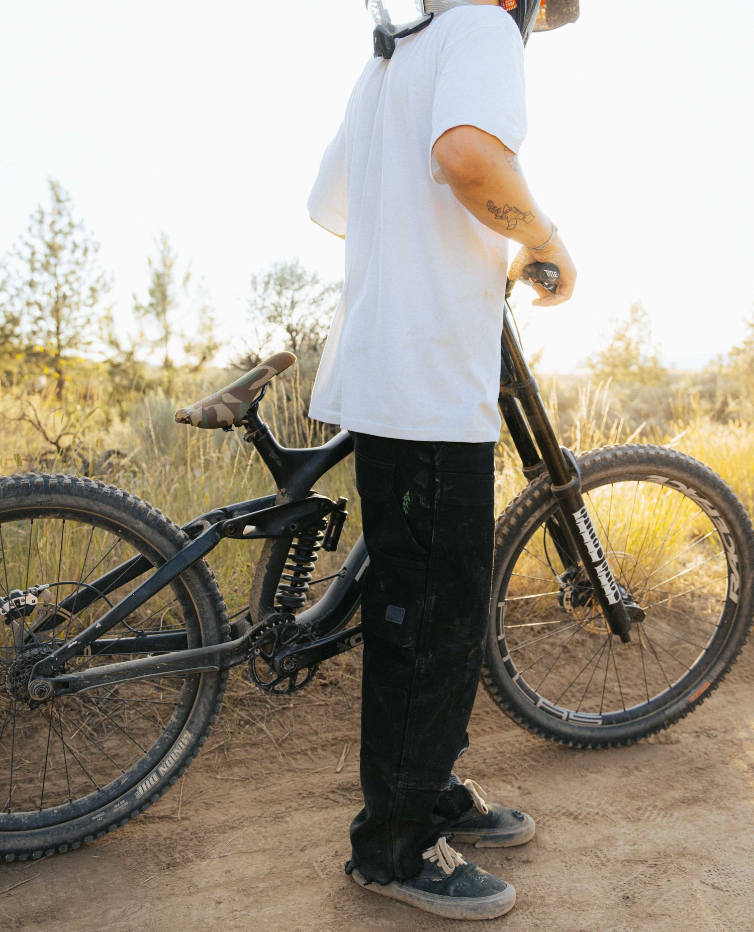 Person standing next to a mountain bike in a desert setting