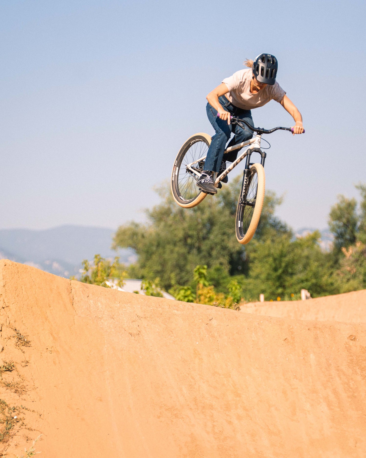 A woman hitting a dirt jump