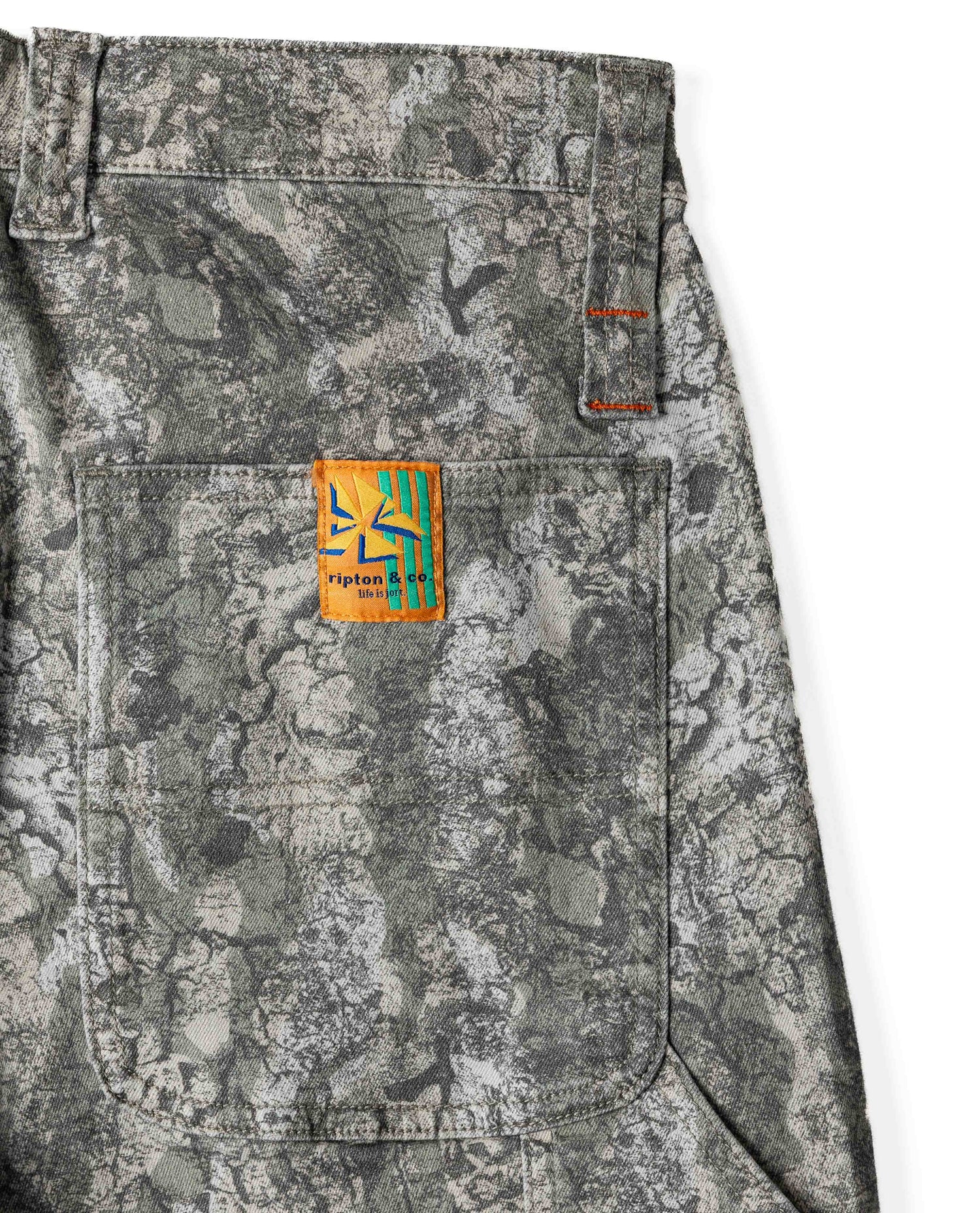 Camouflage pants with a visible brand patch on a white background