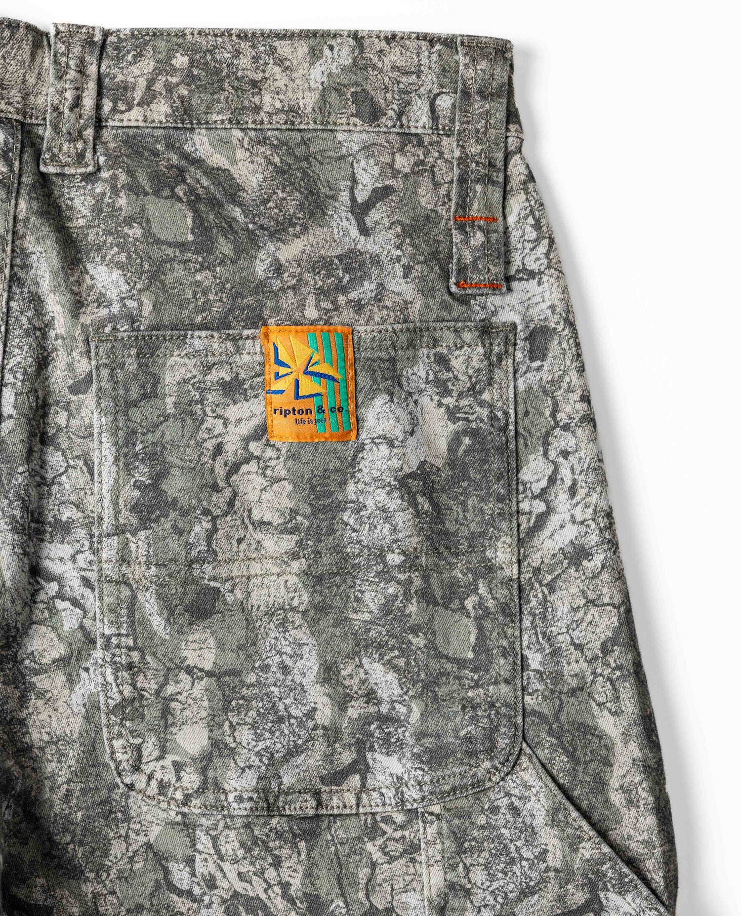 Camouflage pants with a brand logo on the pocket against a white background