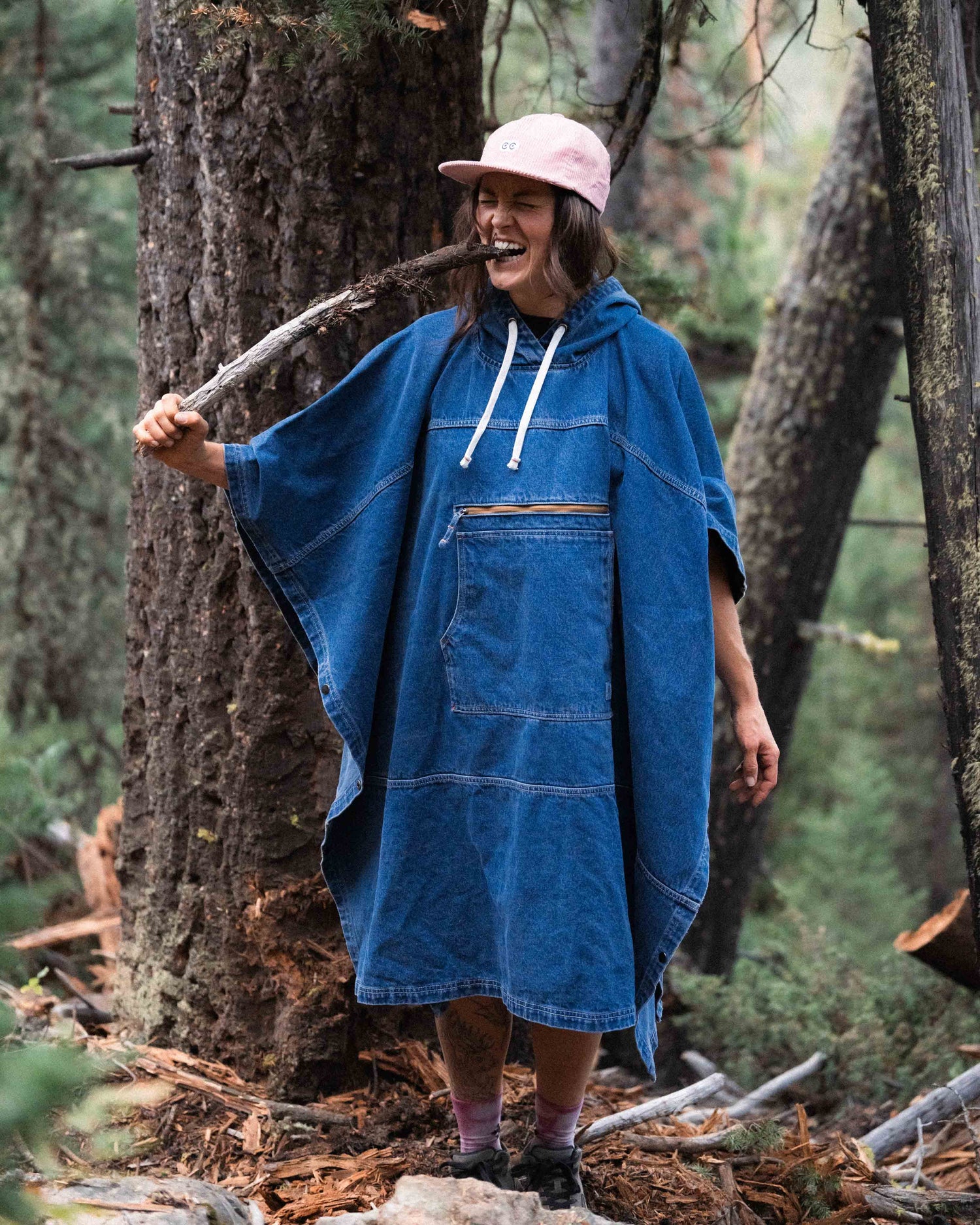 Person in a blue hooded poncho in a forest setting