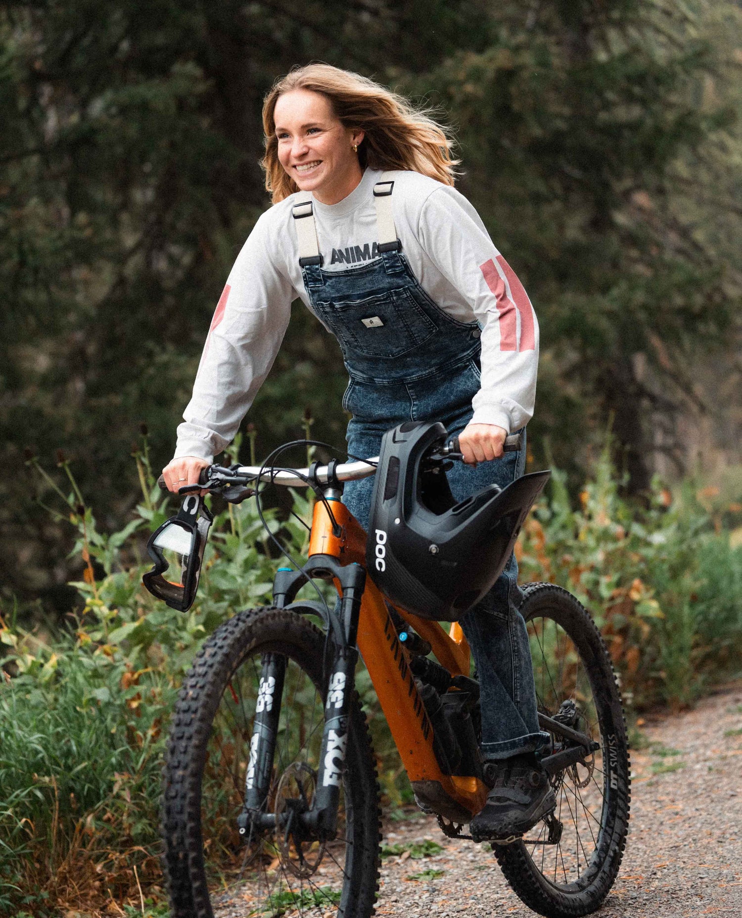 Woman pedaling a bike in Ripton Indigo Marble Overalls.