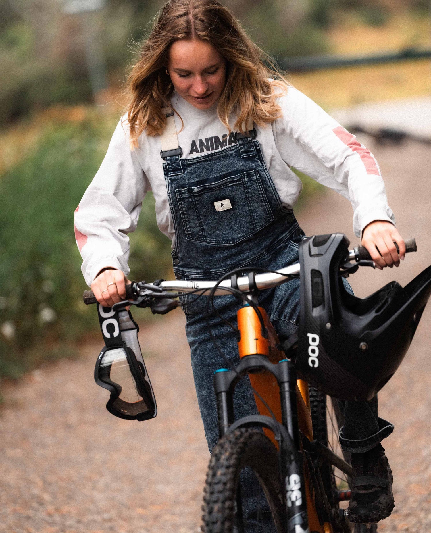Woman pedaling a bike in Ripton Indigo Marble Overalls.