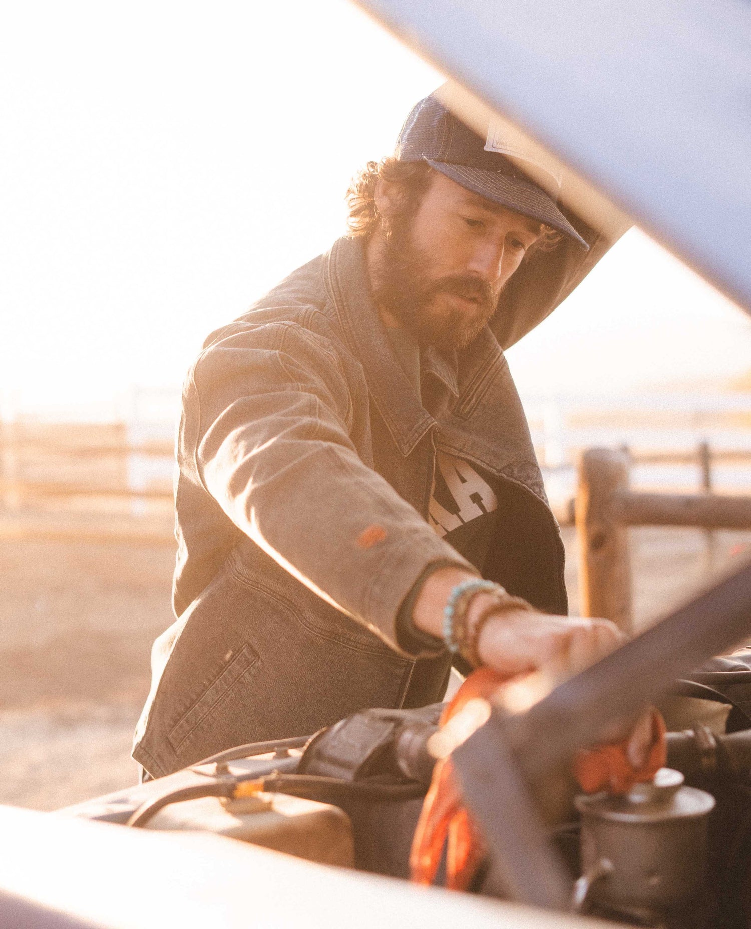 Man fixing a car in Dirty Dave sport utility jacket.