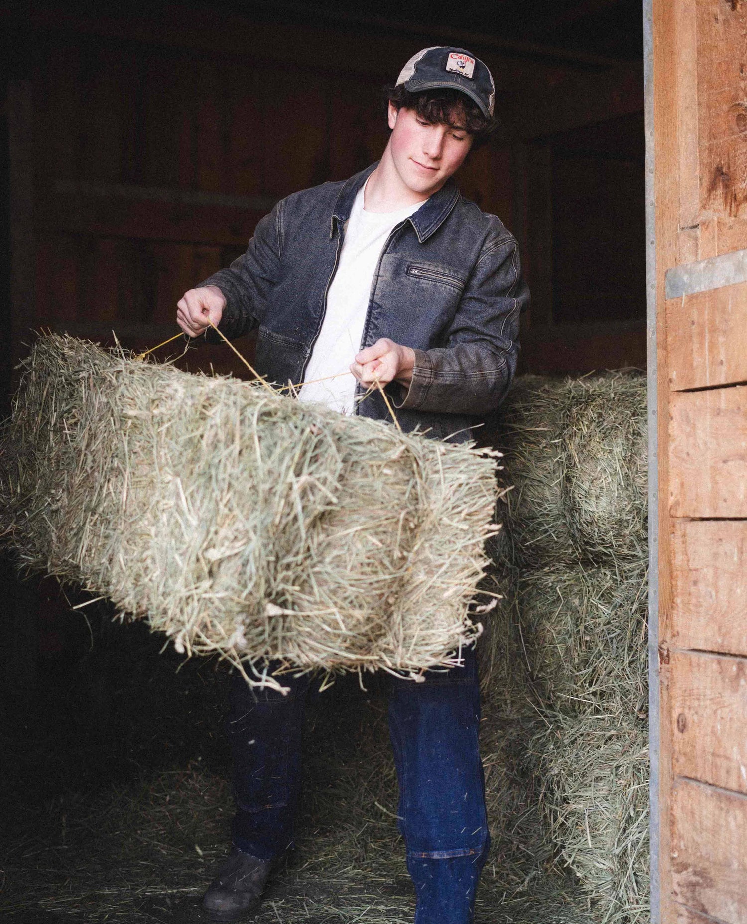 Man throwing hay in Dirty Dave sport utility jacket.