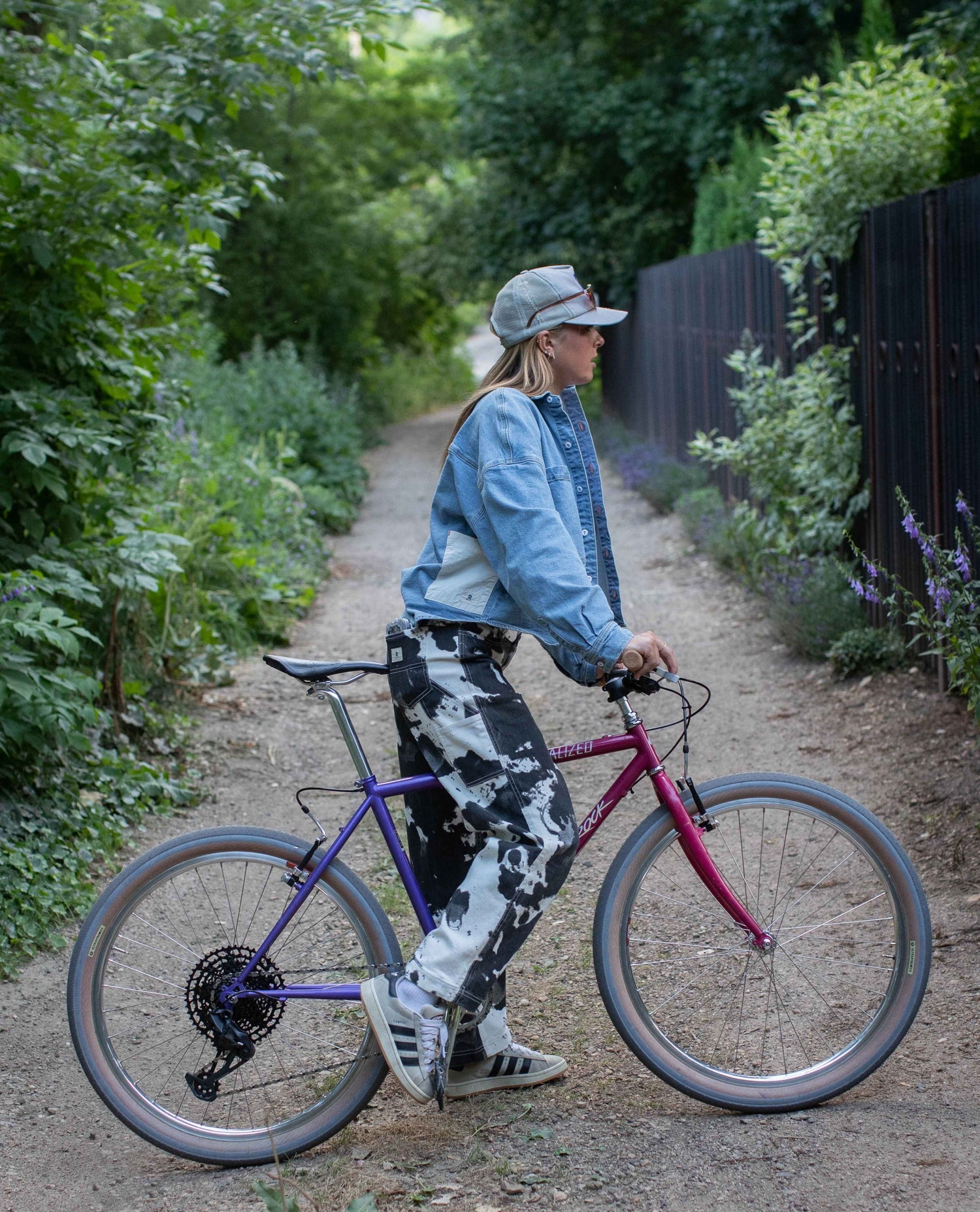 Person riding a bicycle on a path surrounded by greenery