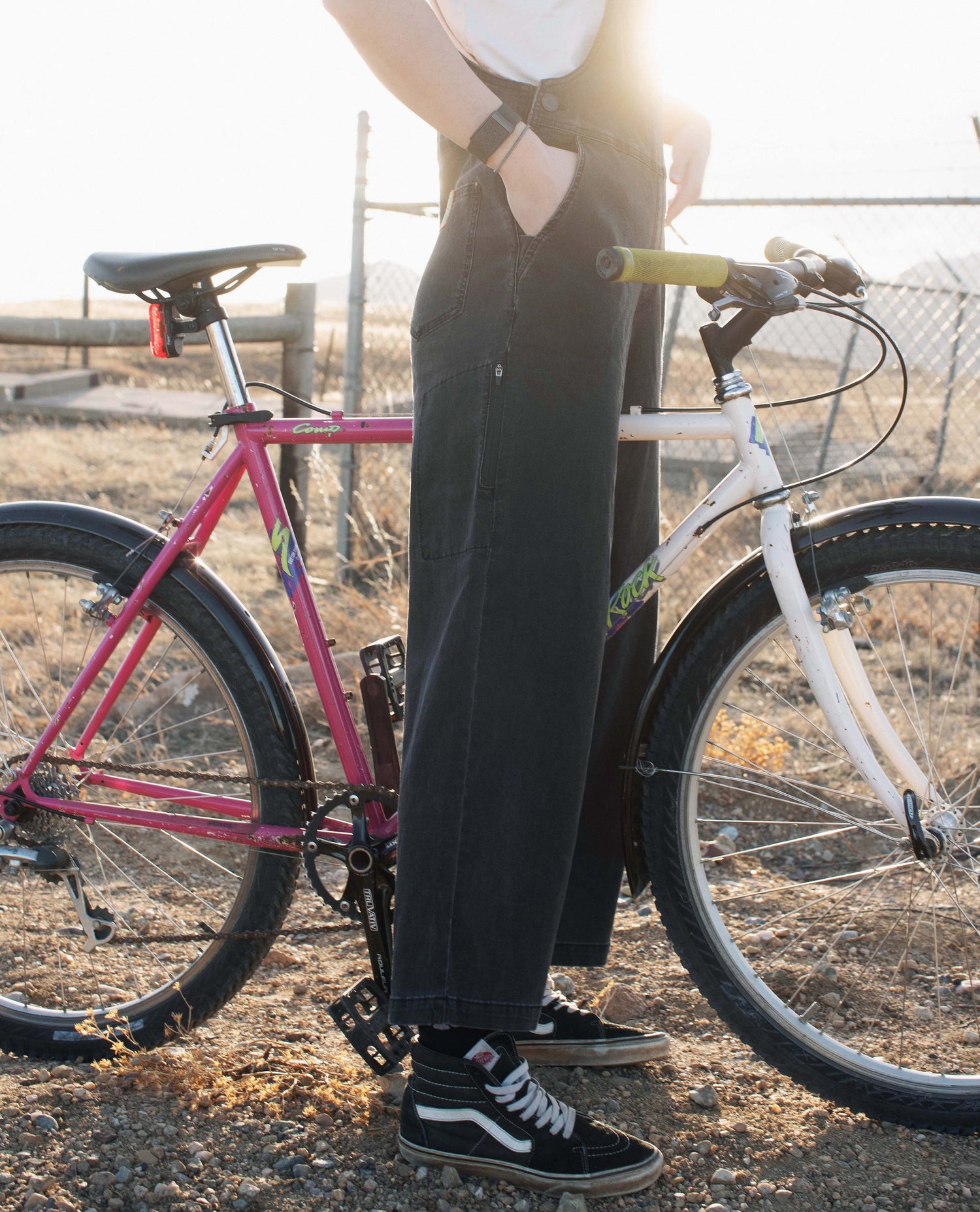 person wearing overalls standing over a bike