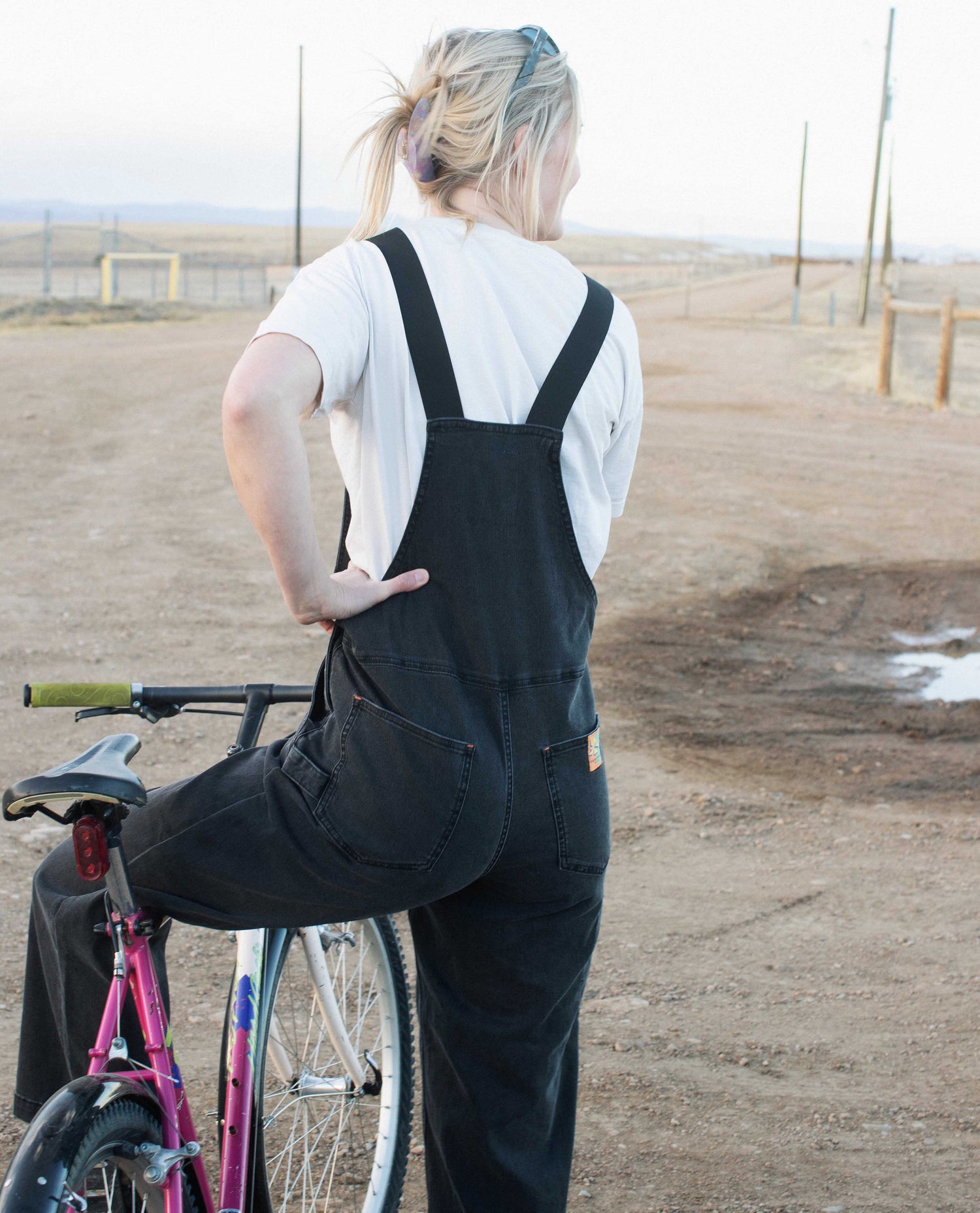 person wearing overalls on bike