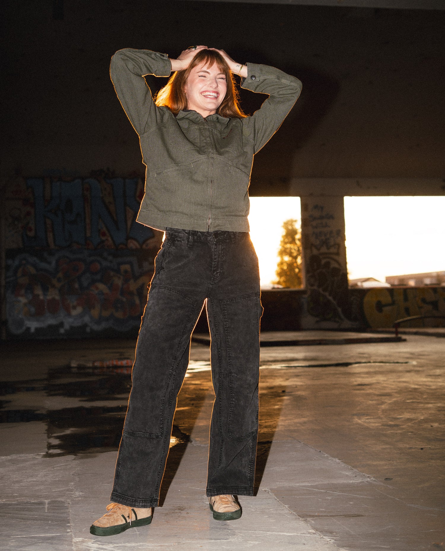 Person standing in a skate park with graffiti on the walls