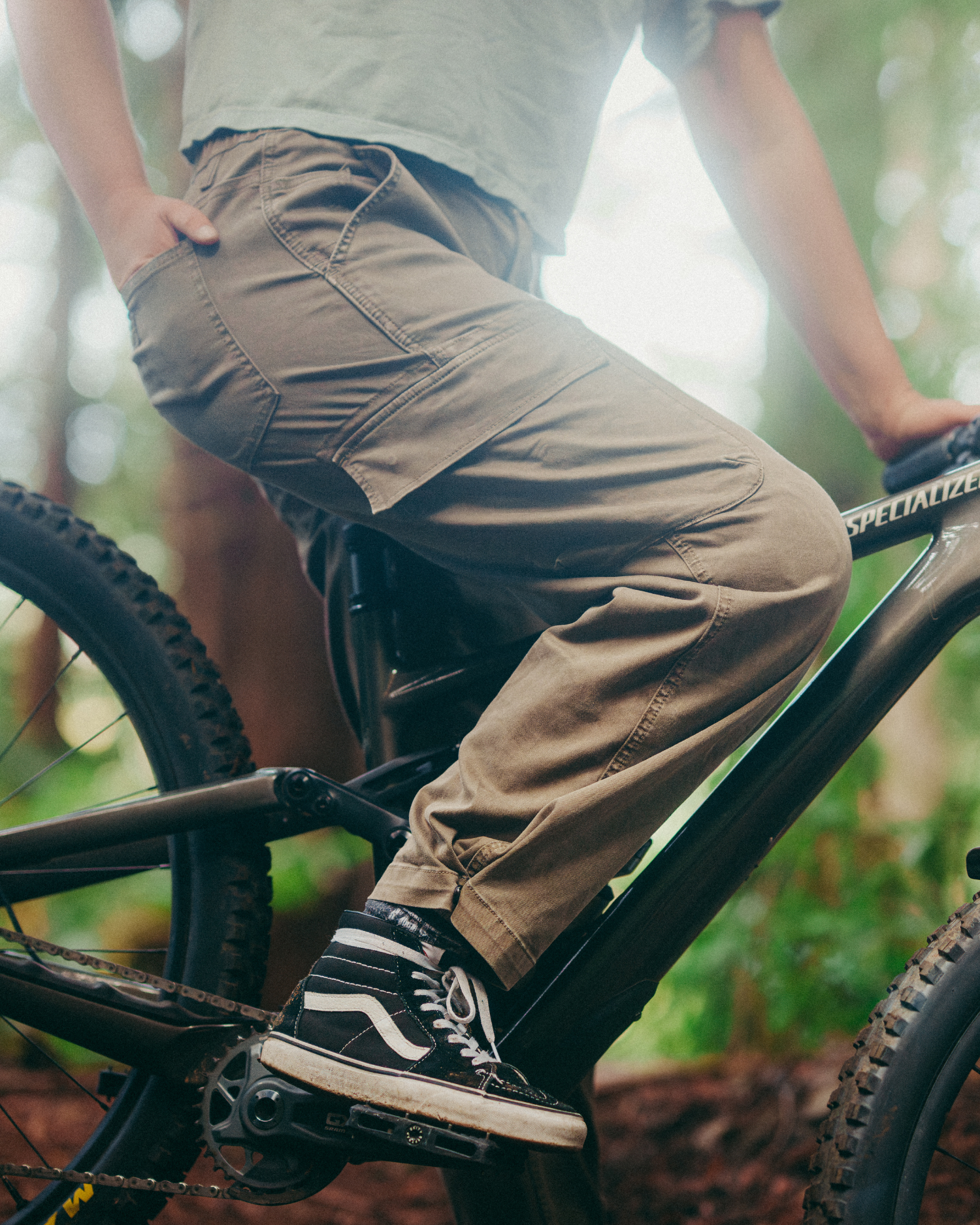 Close-up of brown cargo pants with utility pockets while riding a mountain bike