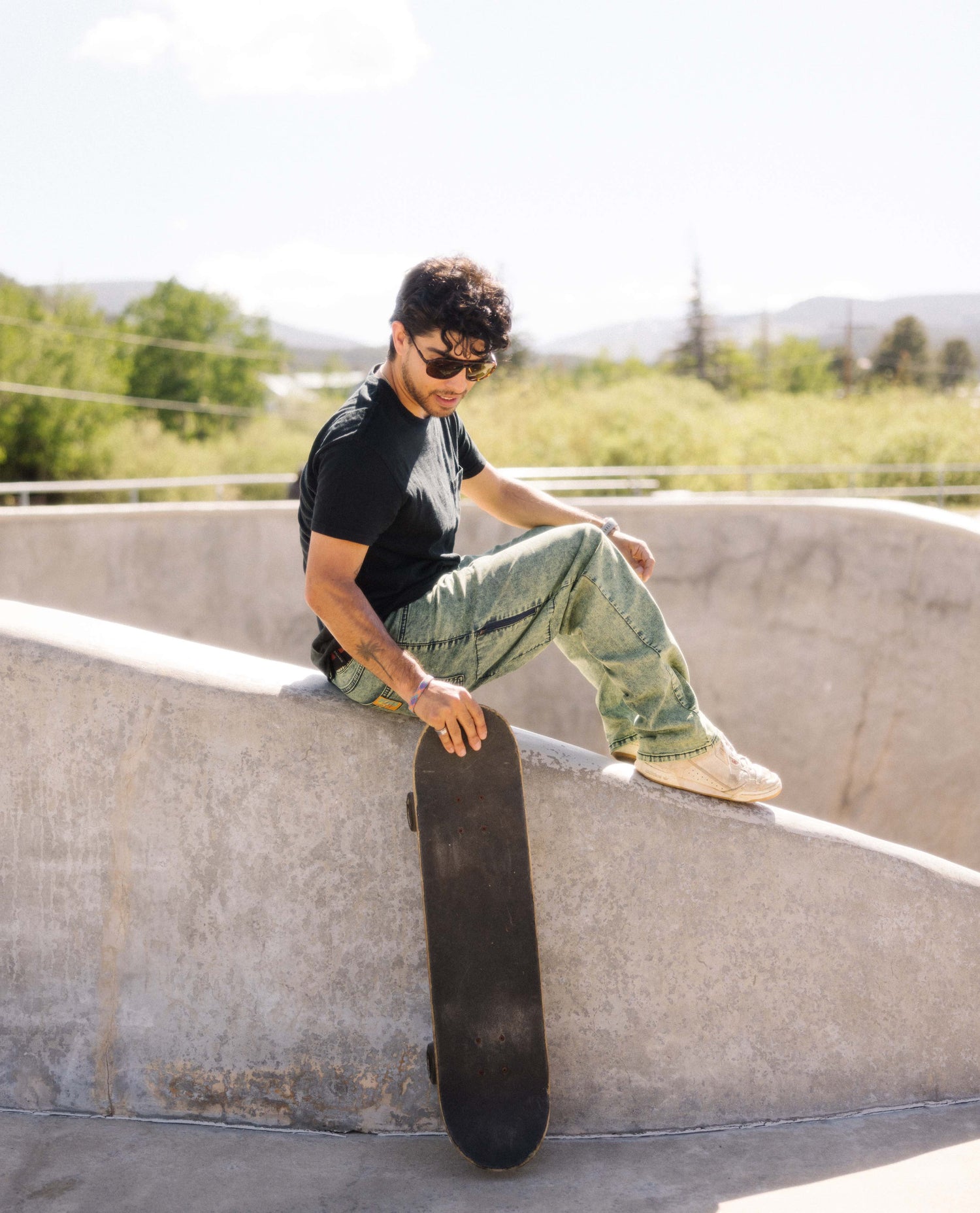 Skateboarder sitting in superlite jeans