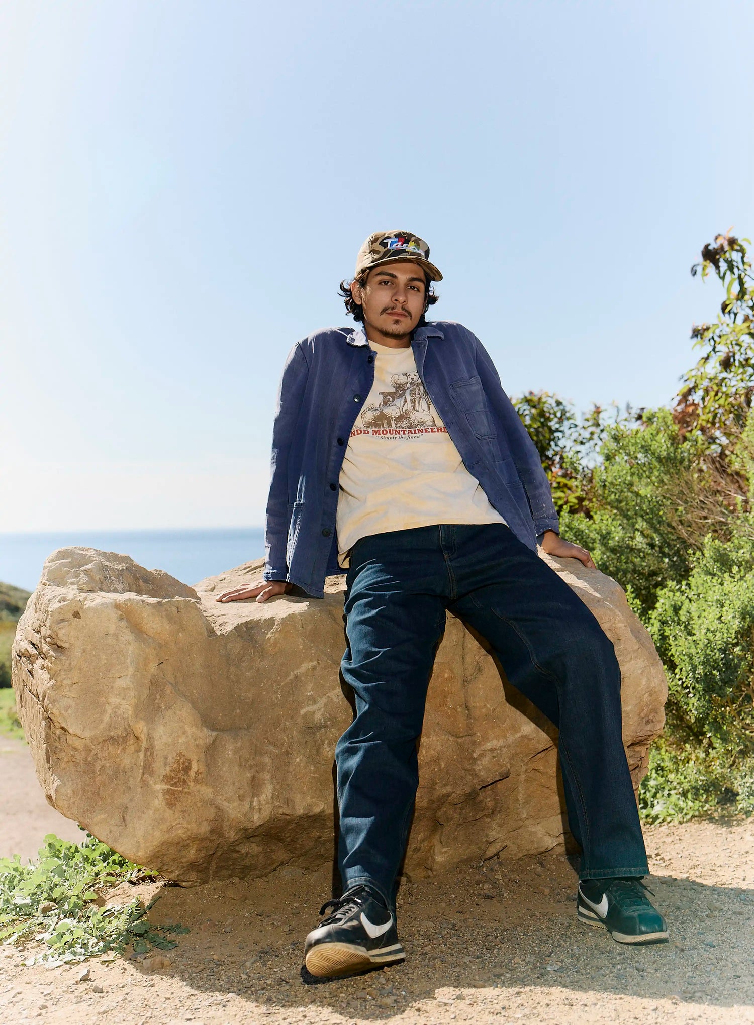 Man sitting on a rock with a scenic background
