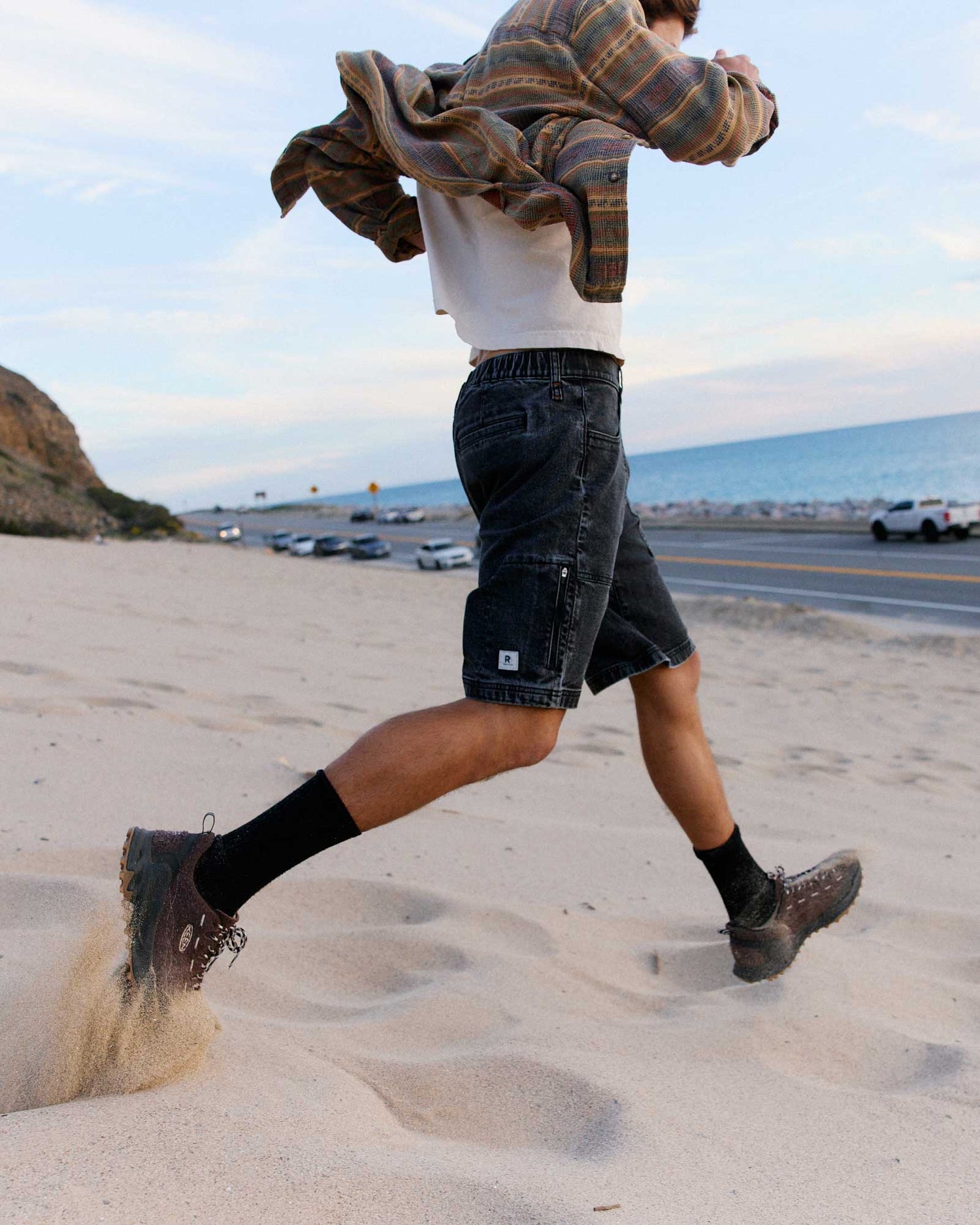 Person running on a sandy beach with a scenic background