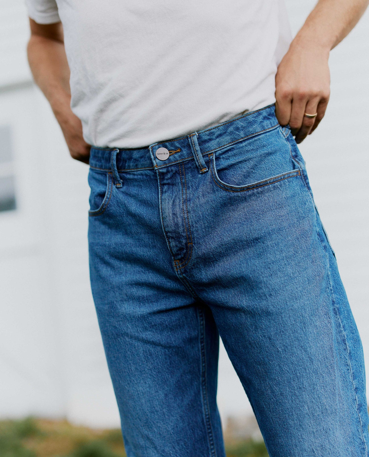 Close up of the waist on mid-wash denim jeans