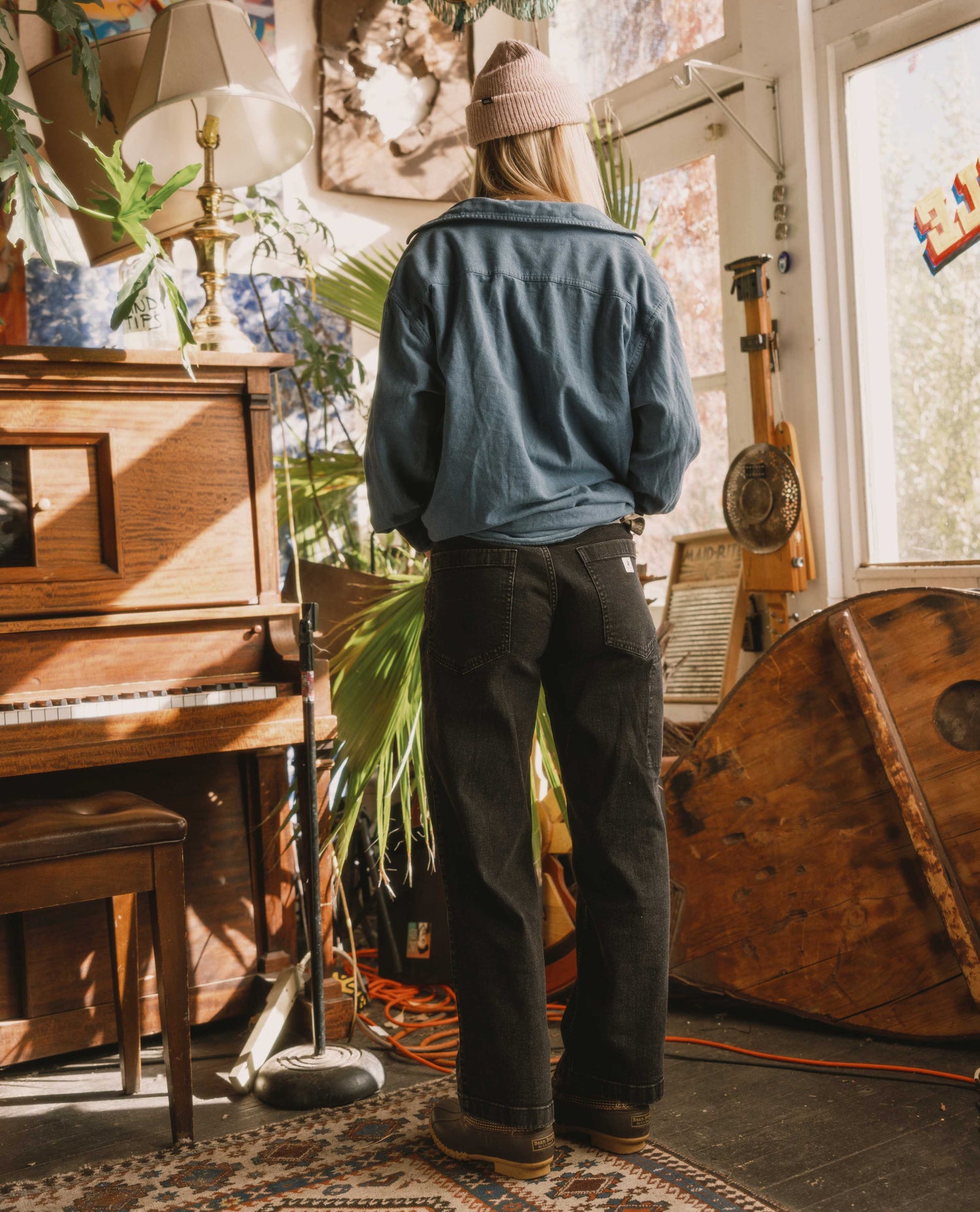 Person standing in a room with a piano and vintage decor