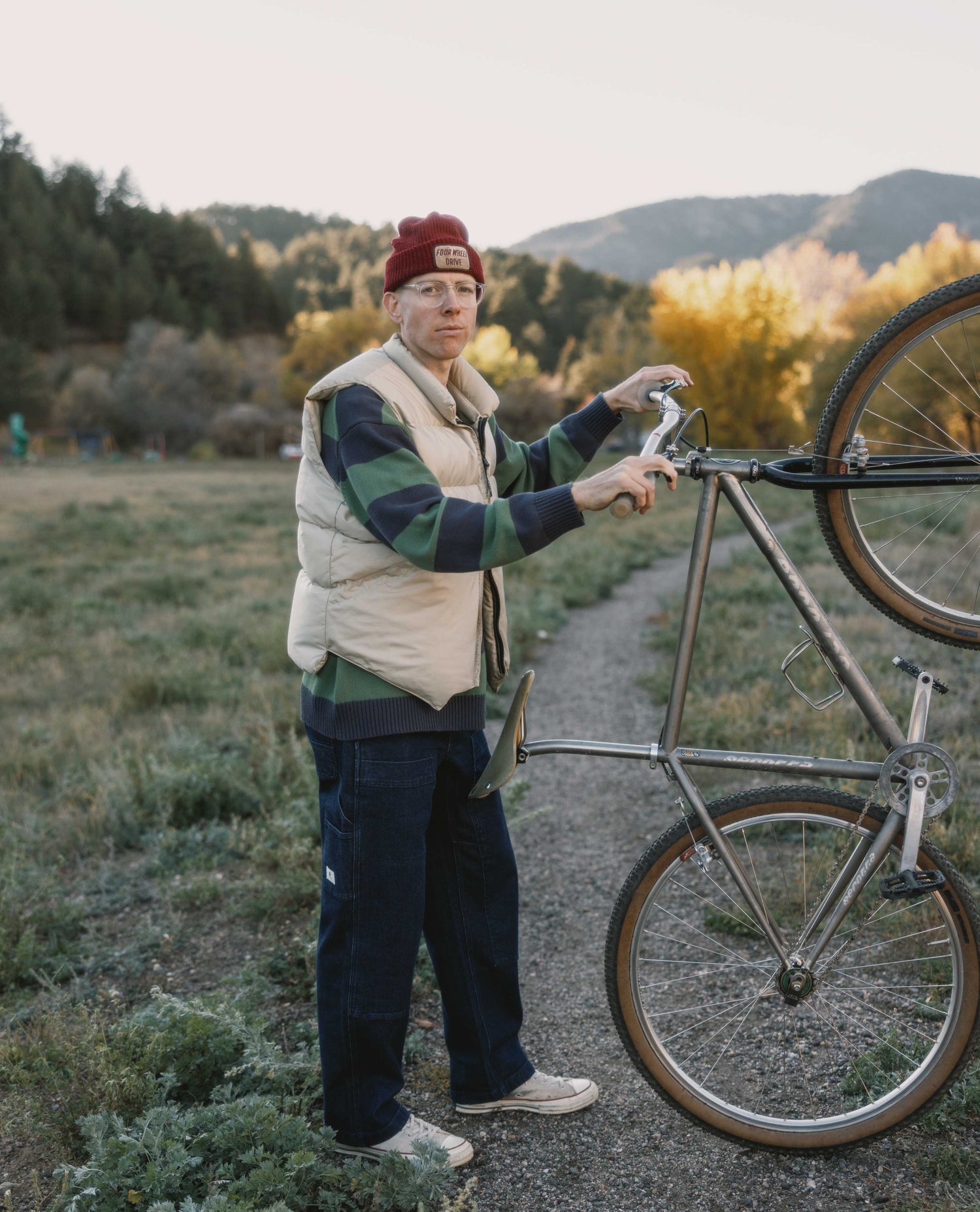 Person with a bicycle on a trail in a natural setting