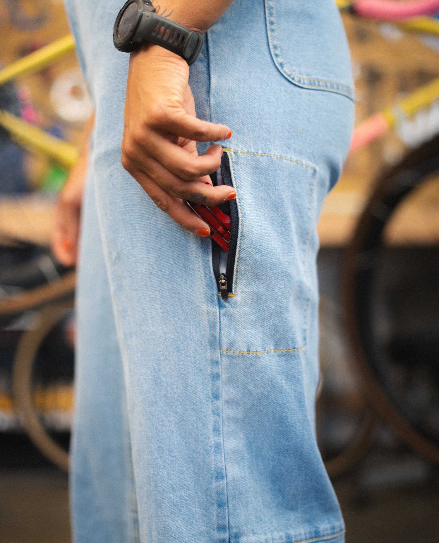 Person wearing a denim apron with a blurred background of bicycles