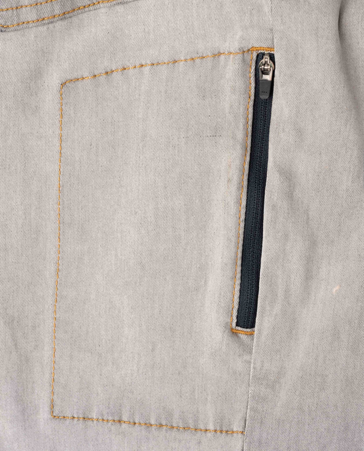 Close-up of a gray pocket with a zipper on a fabric background