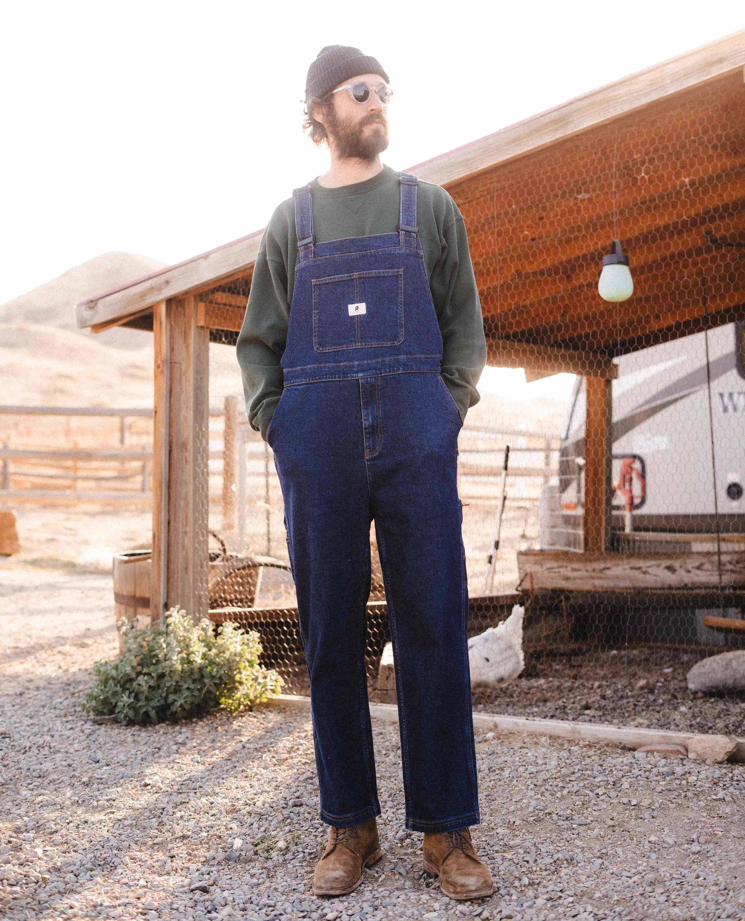 Man wearing blue collar starving jartist tuxedos at a farm. 