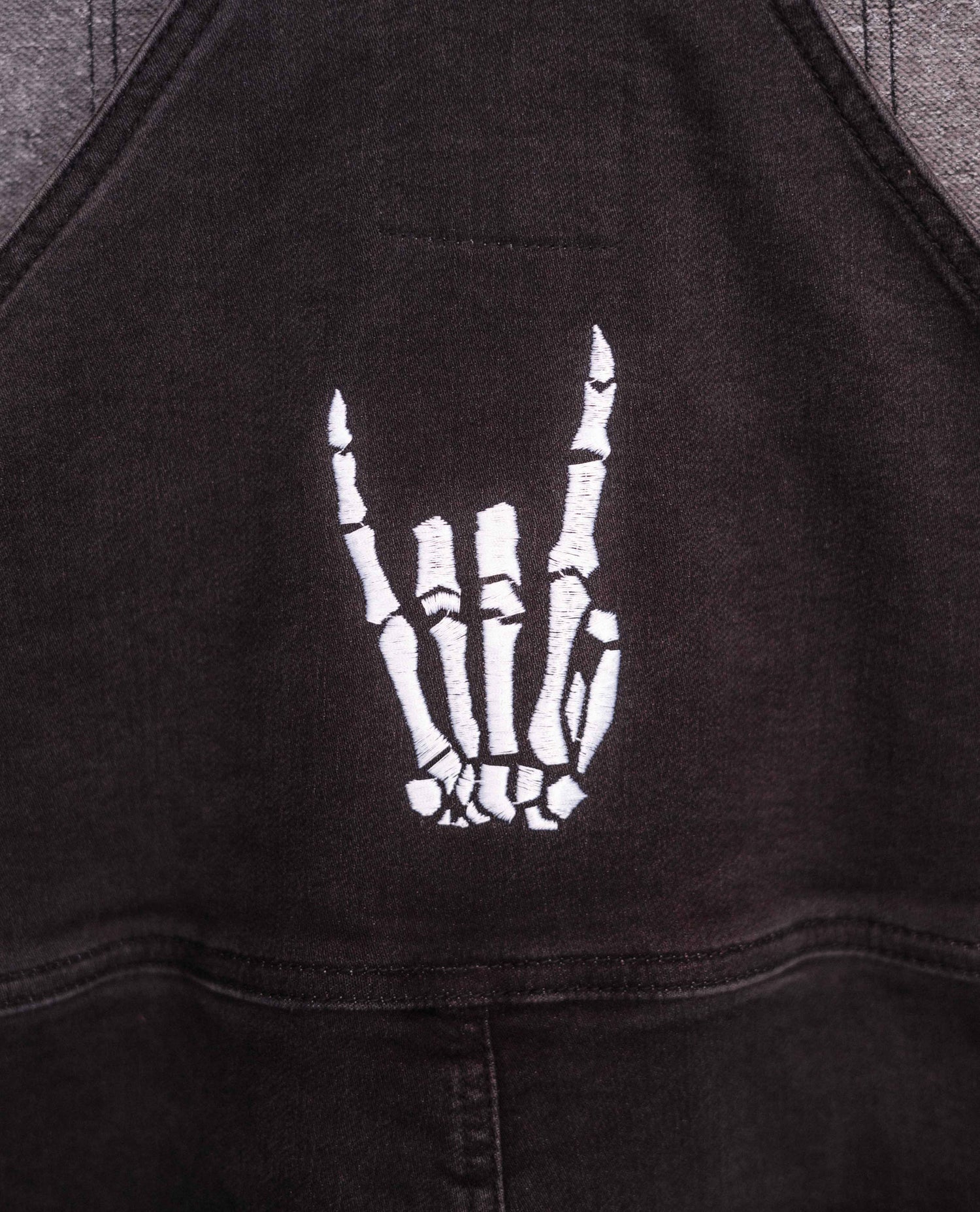 Skeleton hand embroidered on overalls details