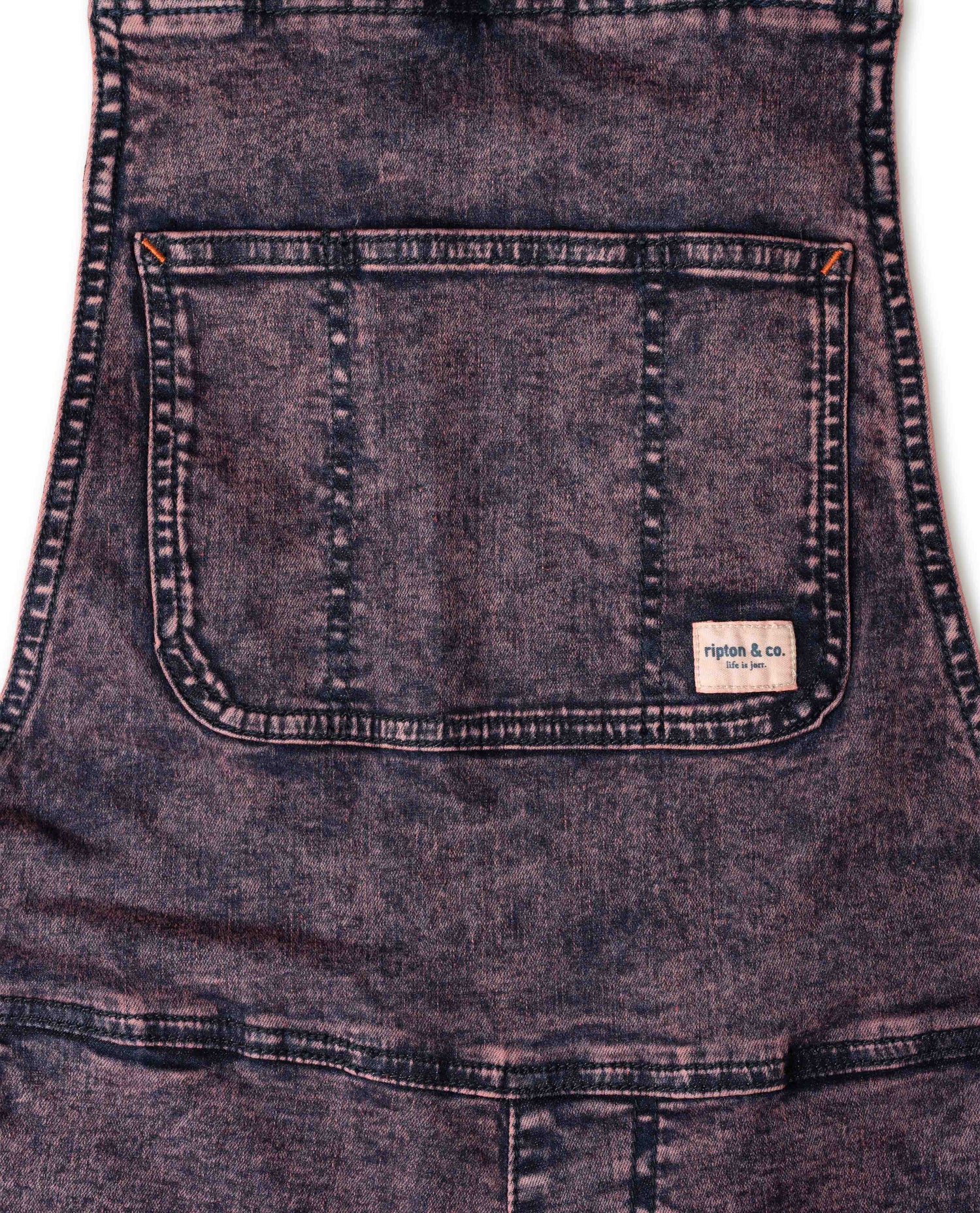 Close-up of a denim apron with a brand label on a white background