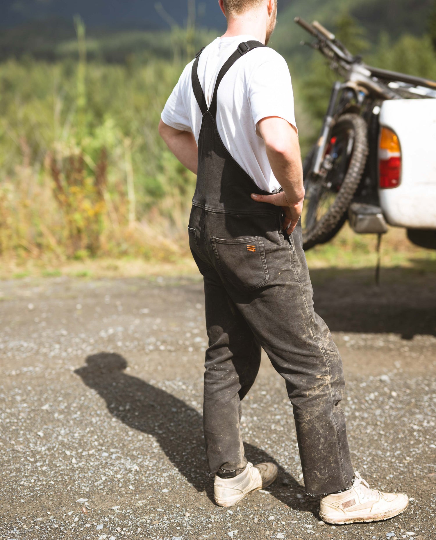 Guy standing around by a truck in overalls