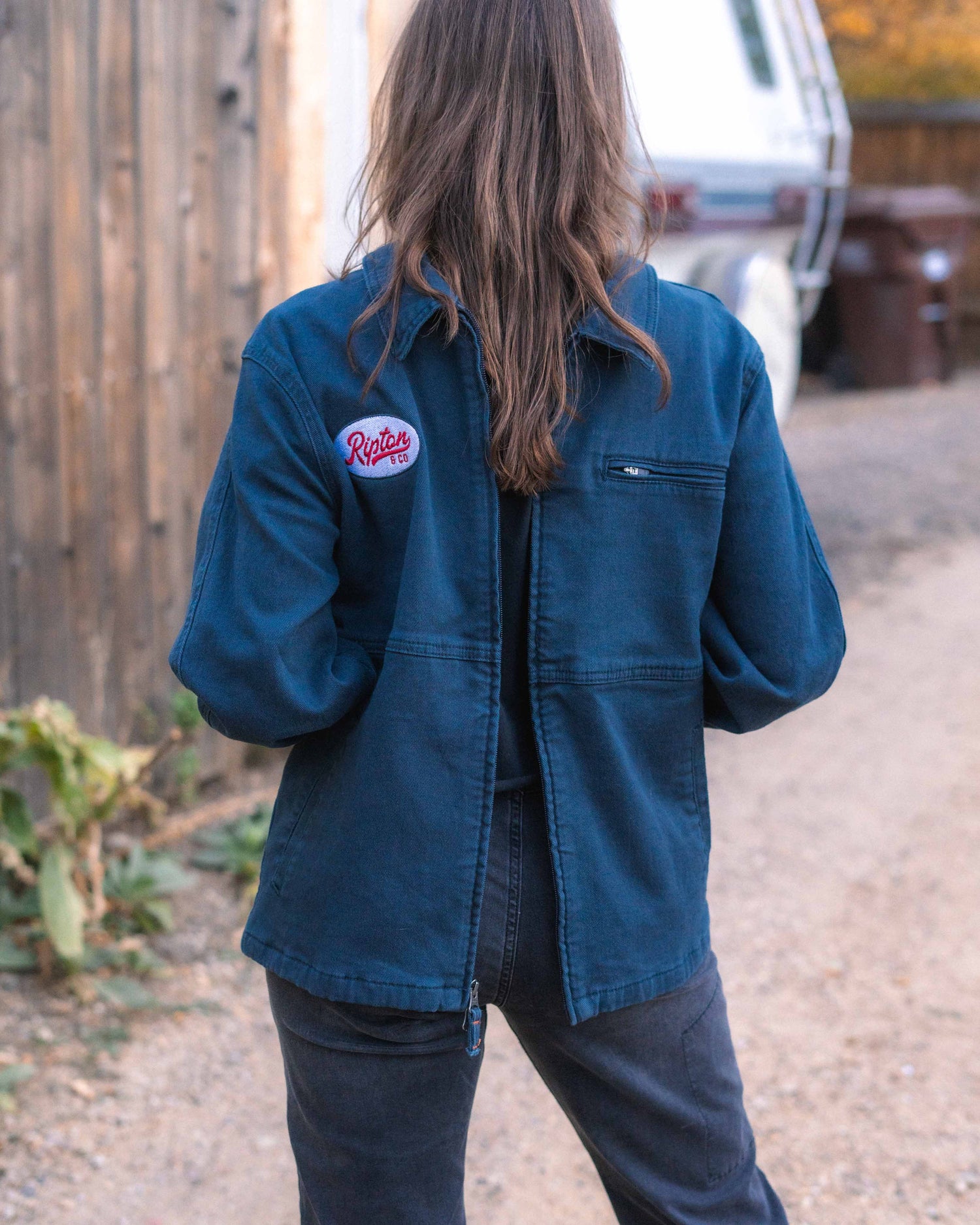 Navy jacket with mechanics embroidery on a girl facing backward