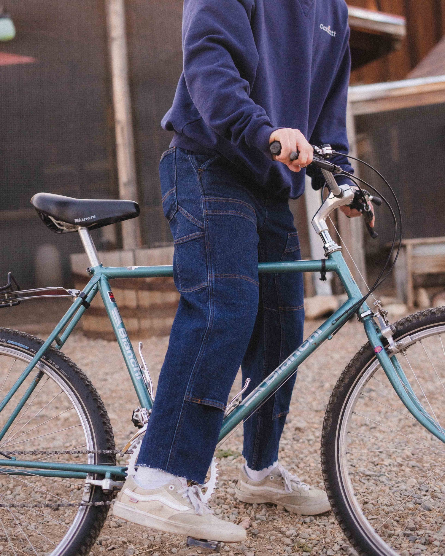 leg close up of guy astride a bike in jeans