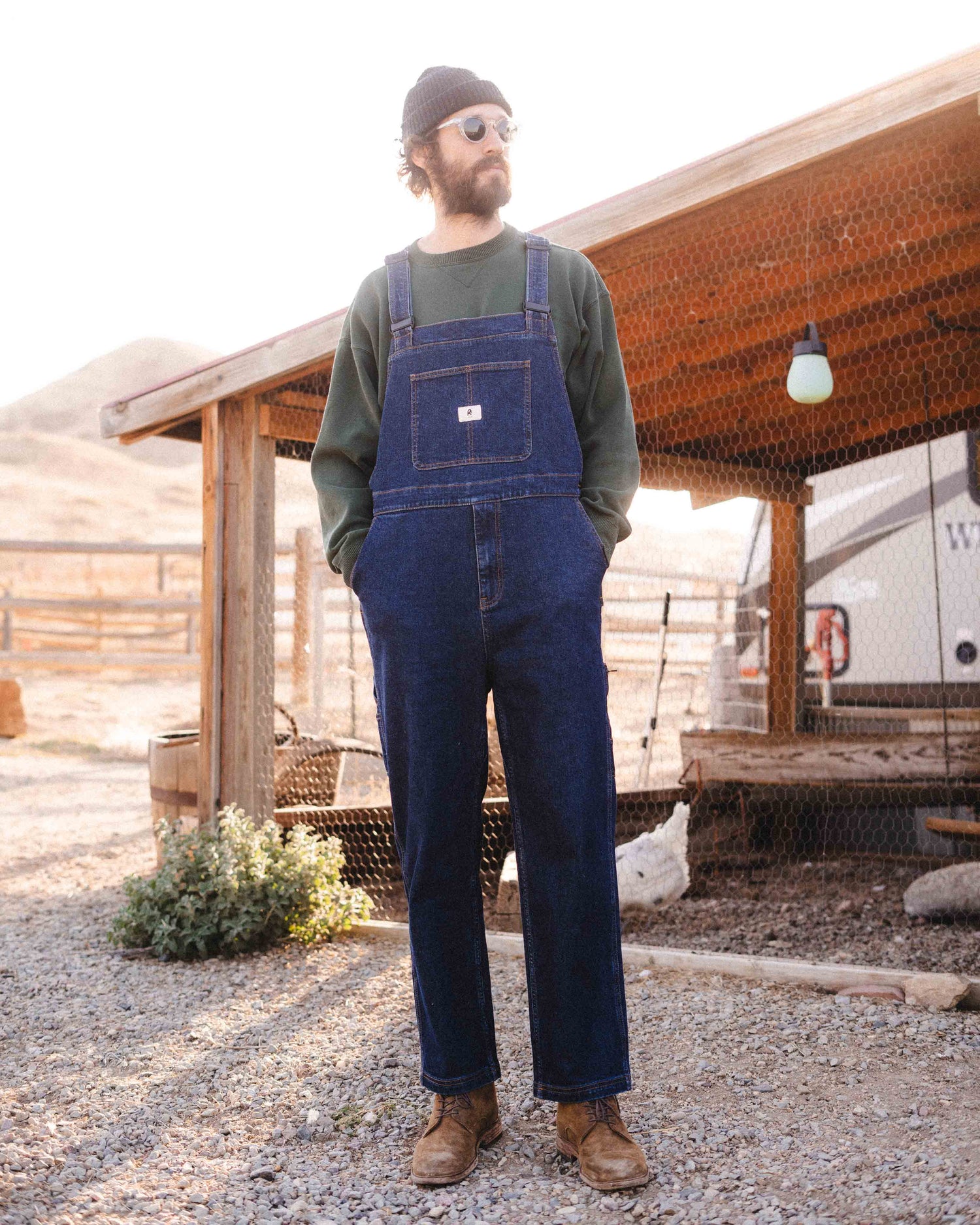 A man wearing Starving Jartist Overalls in Blue Collar wash