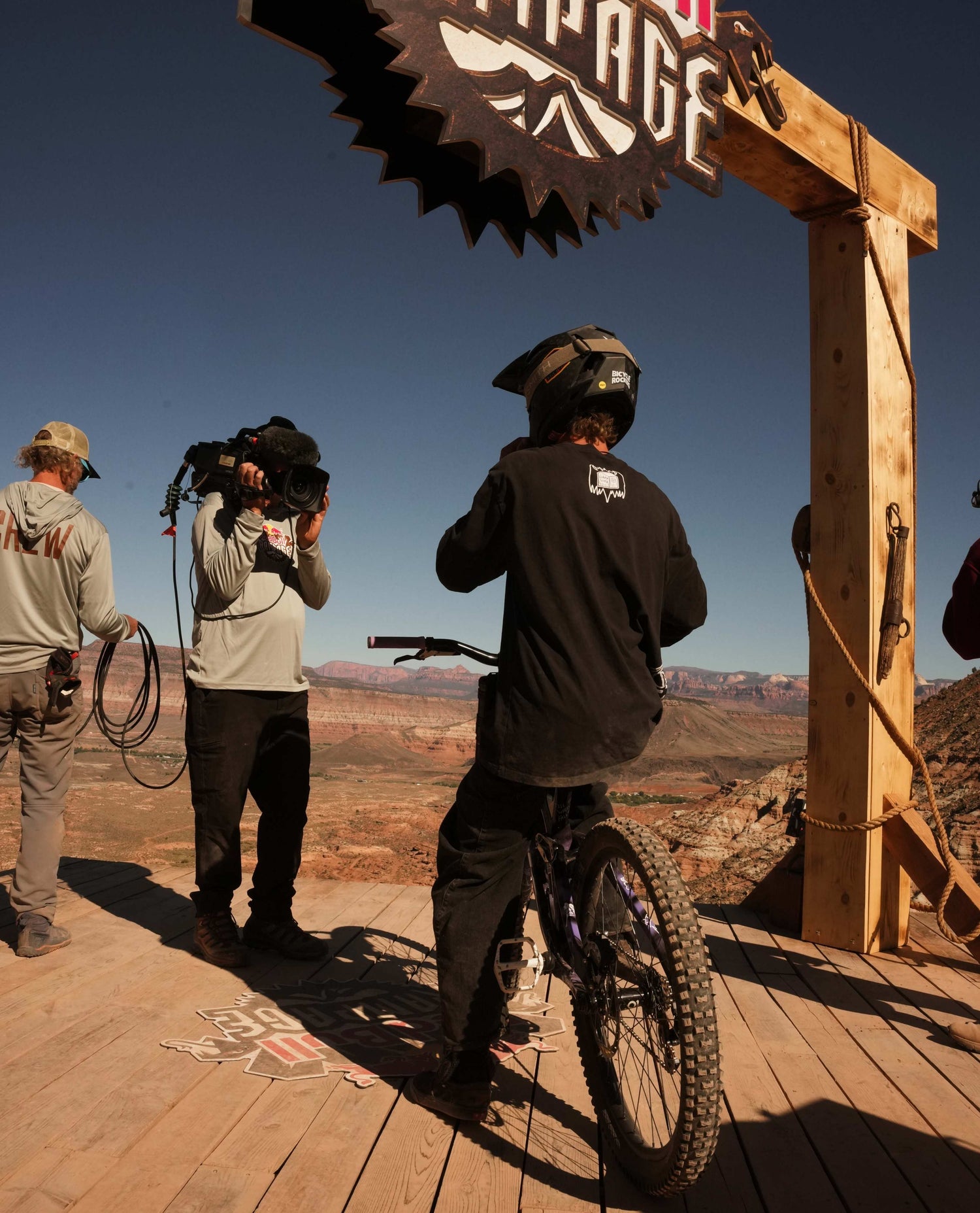 Person on a bike with a camera crew and 'Ride The Line' sign in the background
