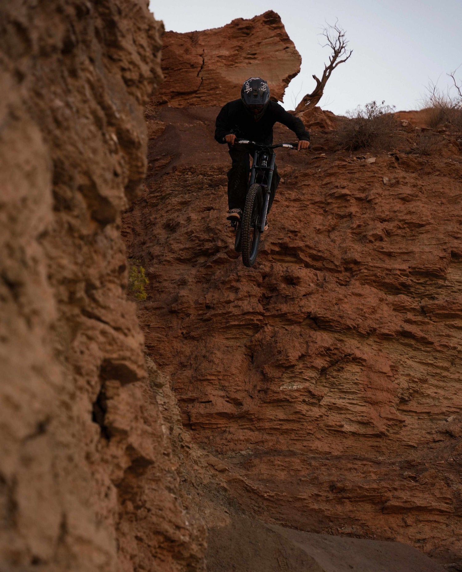 Person riding a bicycle on a rocky cliff