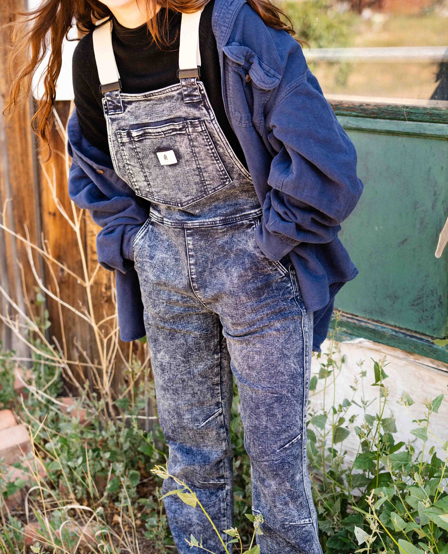 Woman wearing Indigo Marble denim overalls