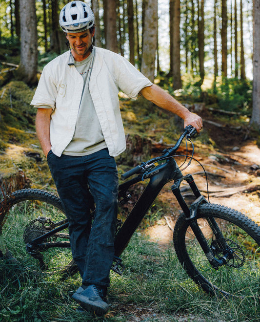 Dave wearing diesel superlite utility jeans posing with his bike in the forest