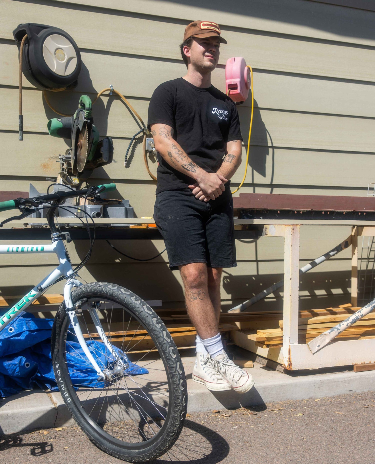 Man standing next to a bicycle with a building in the background
