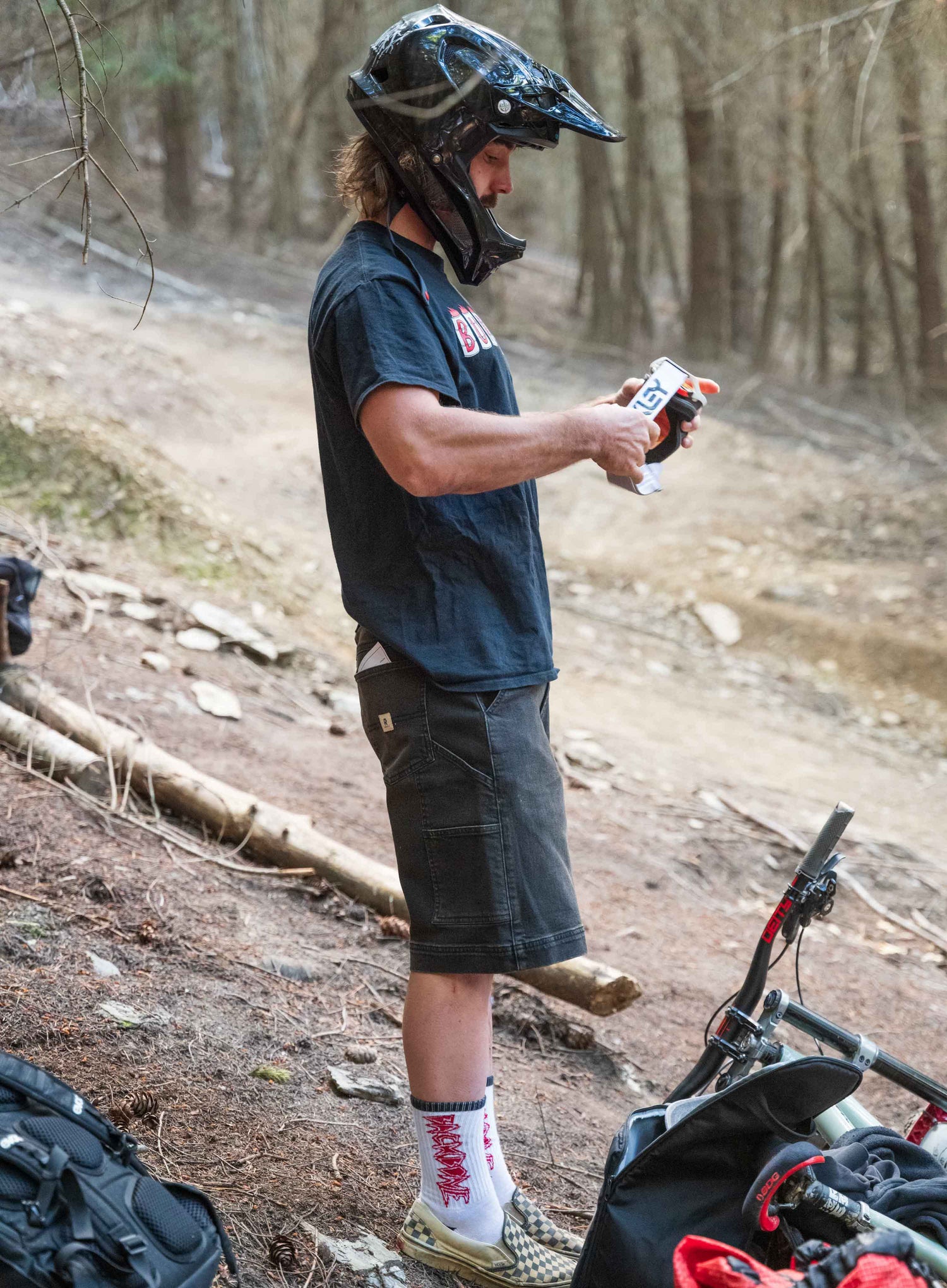 Person in outdoor setting with helmet and bike, holding a device