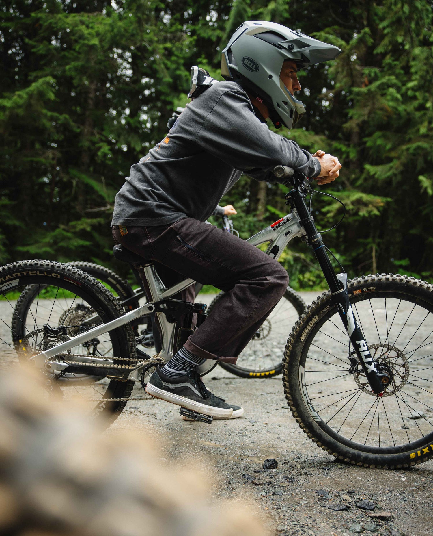 Person riding a mountain bike on a trail with trees in the background