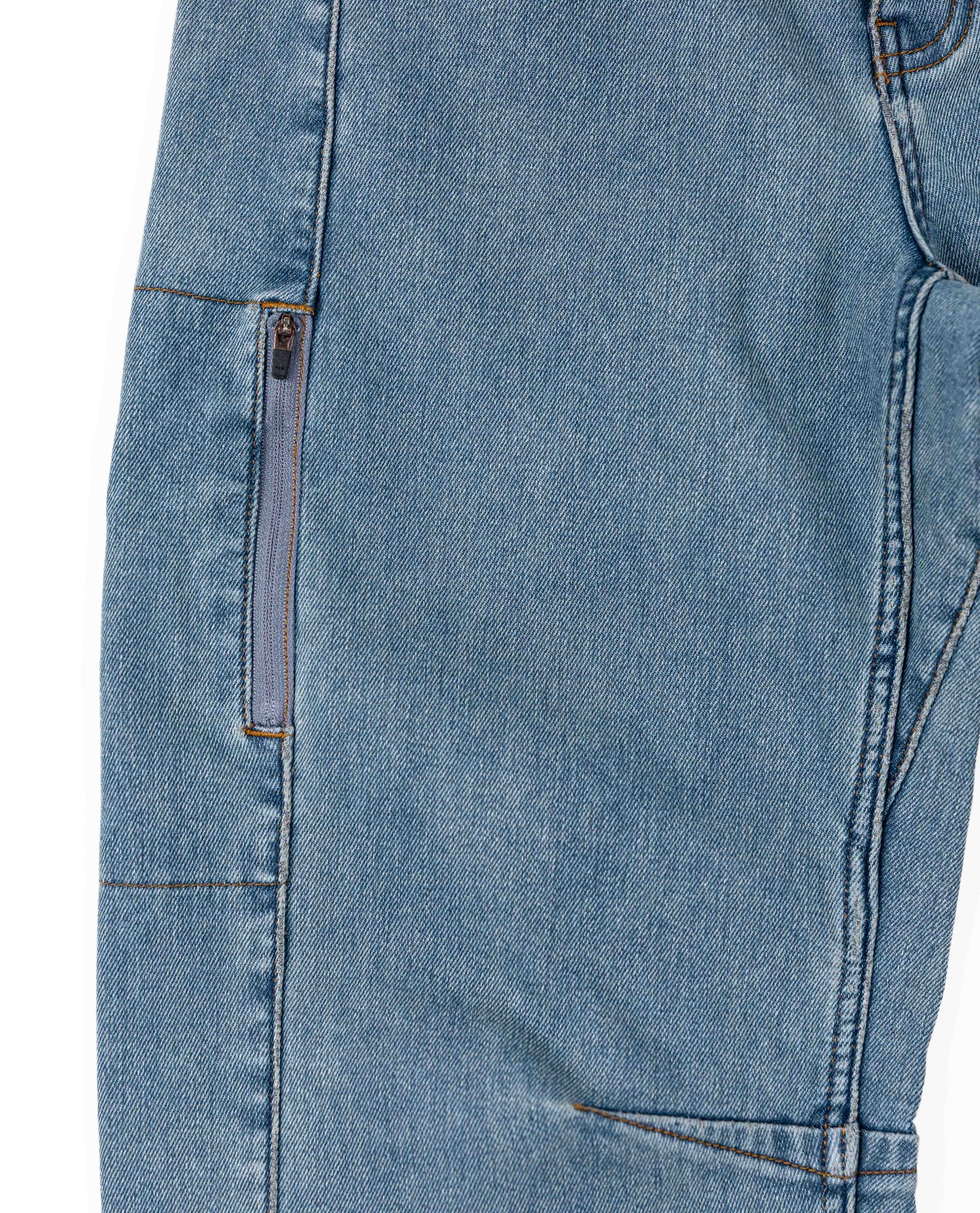 Close-up of blue denim jeans with a zipper detail on a white background