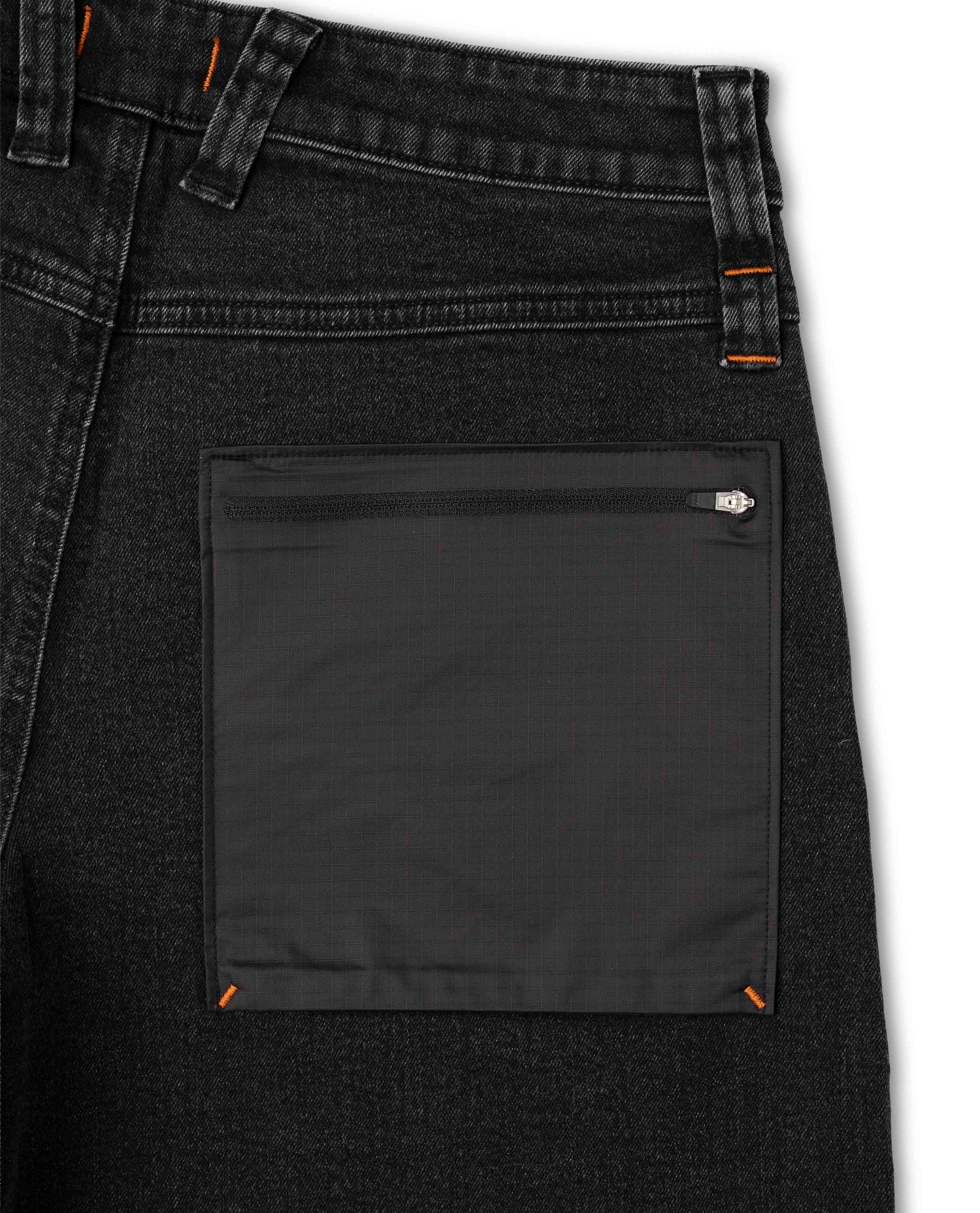 Close-up of a black denim pocket with a zipper on a white background