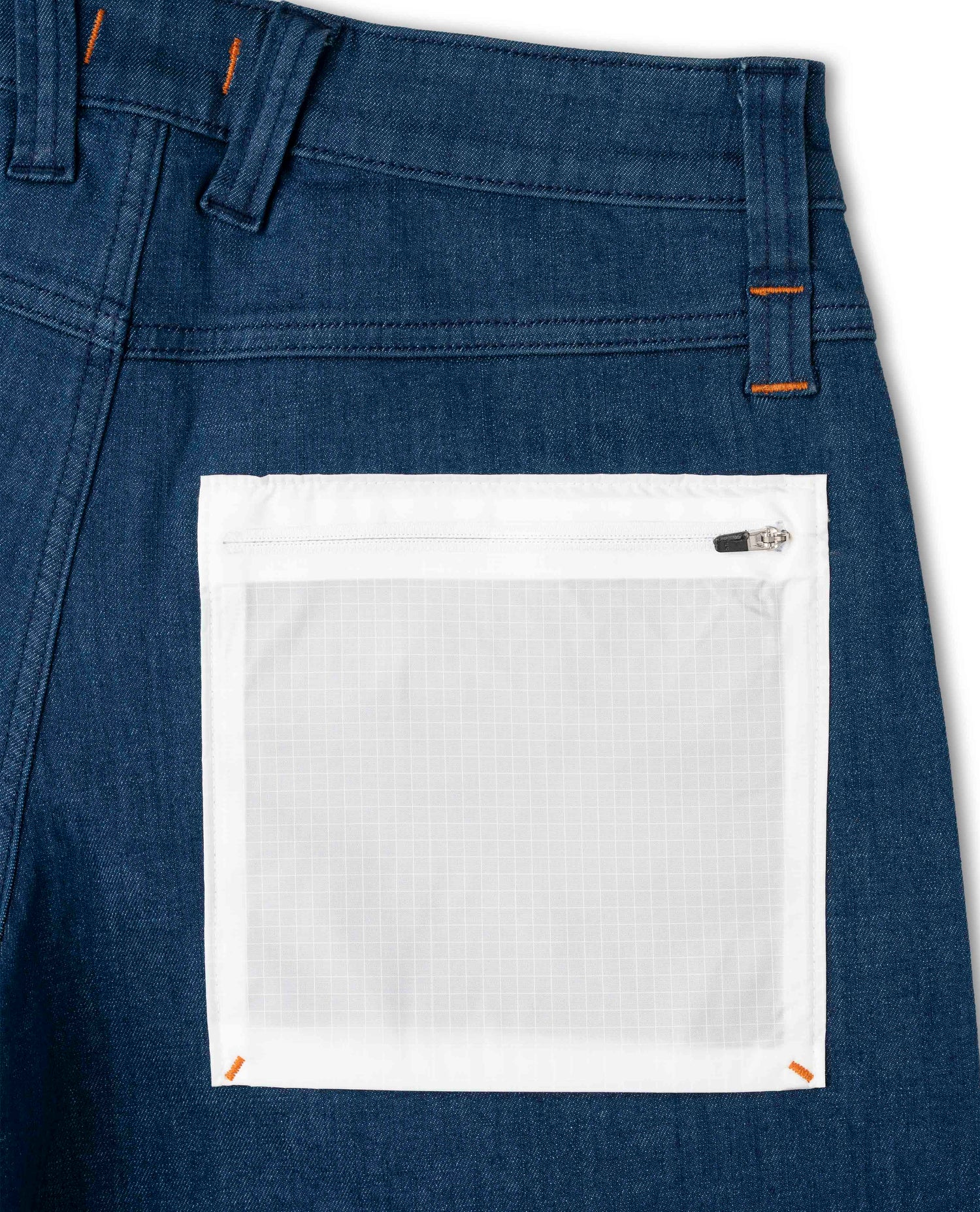 Close-up of blue denim pants with a white pocket on a white background