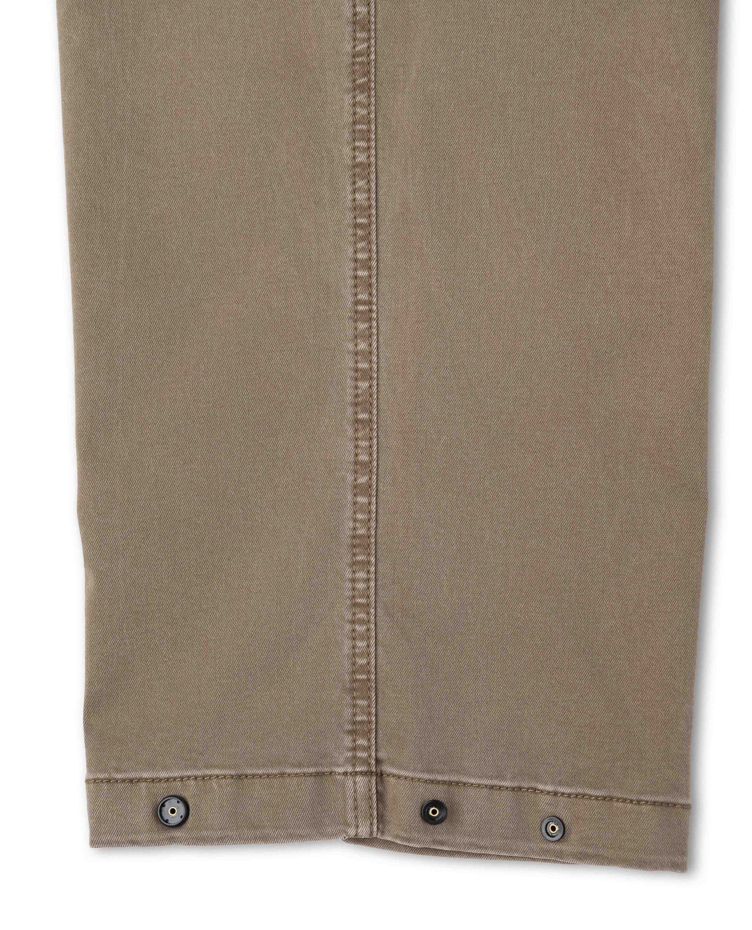 Close up of snap detail of brown pant on white background