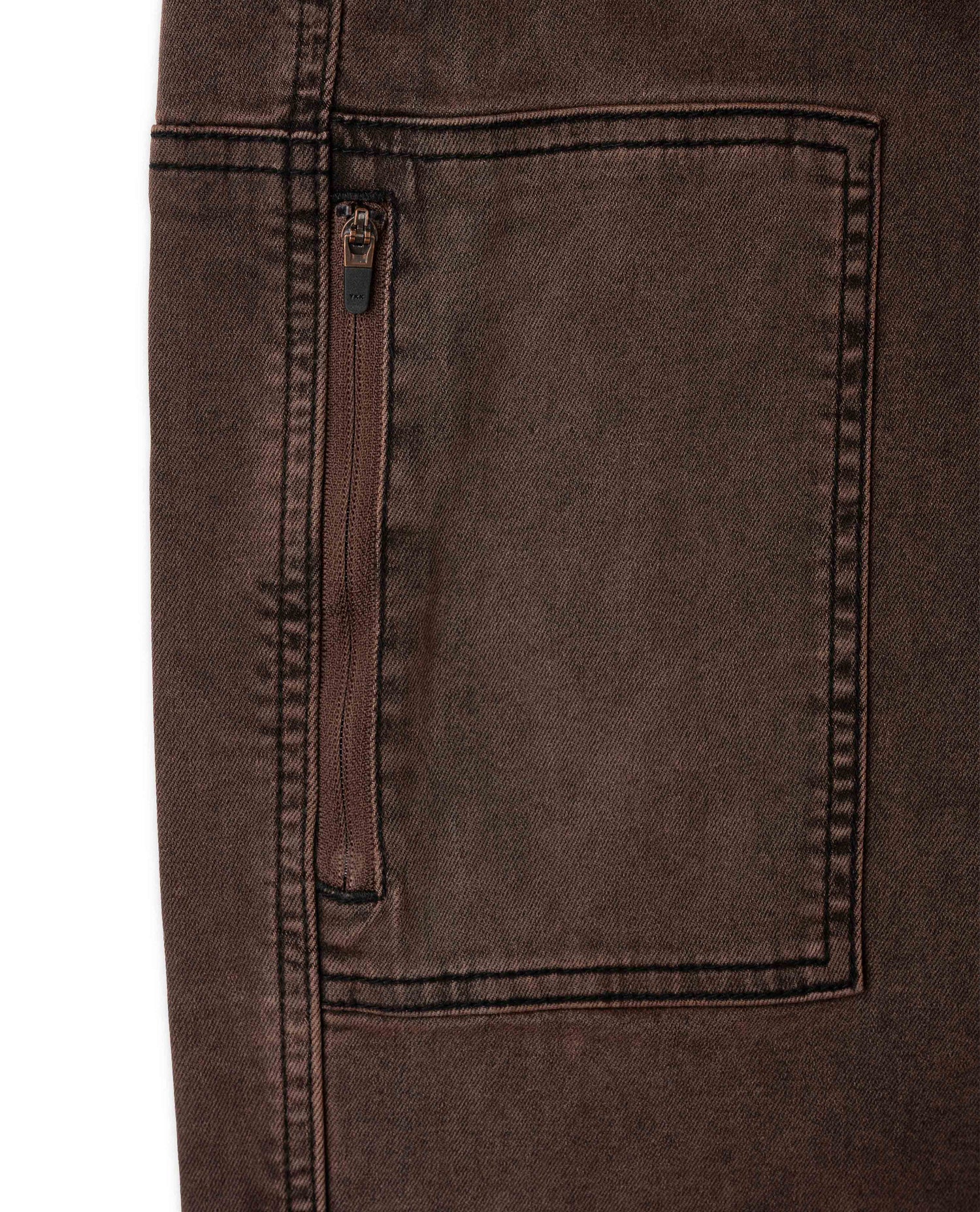 Close-up of a brown denim pocket with stitching detail on a white background