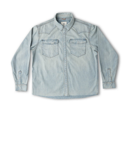 A light blue denim long-sleeve button-up shirt with two chest pockets, laid flat against a white background.