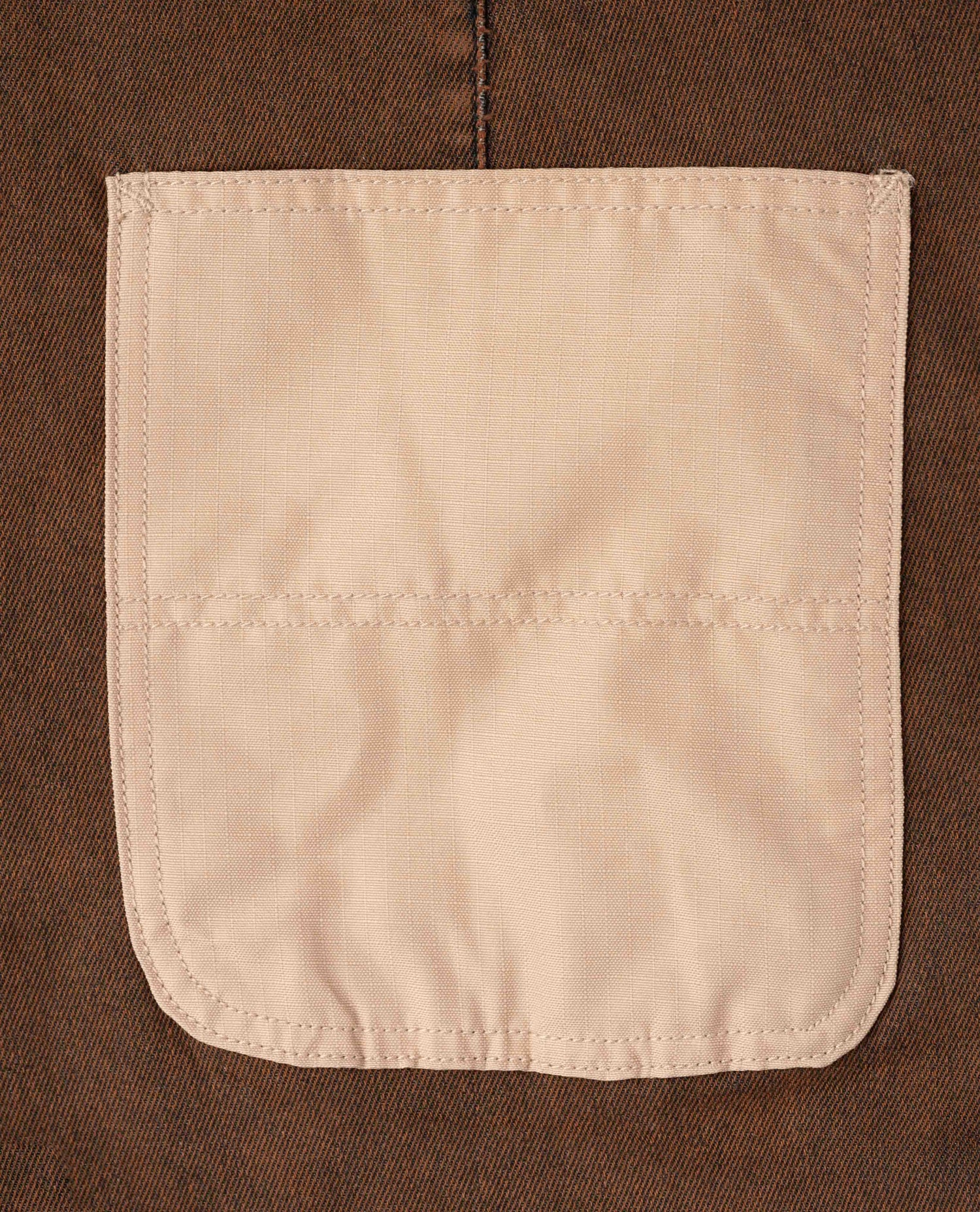 Beige pocket on a brown fabric background