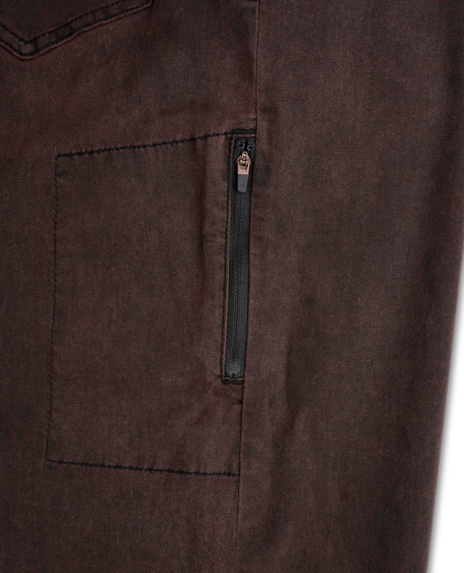 Close-up of a brown fabric with a zipper pocket on a white background